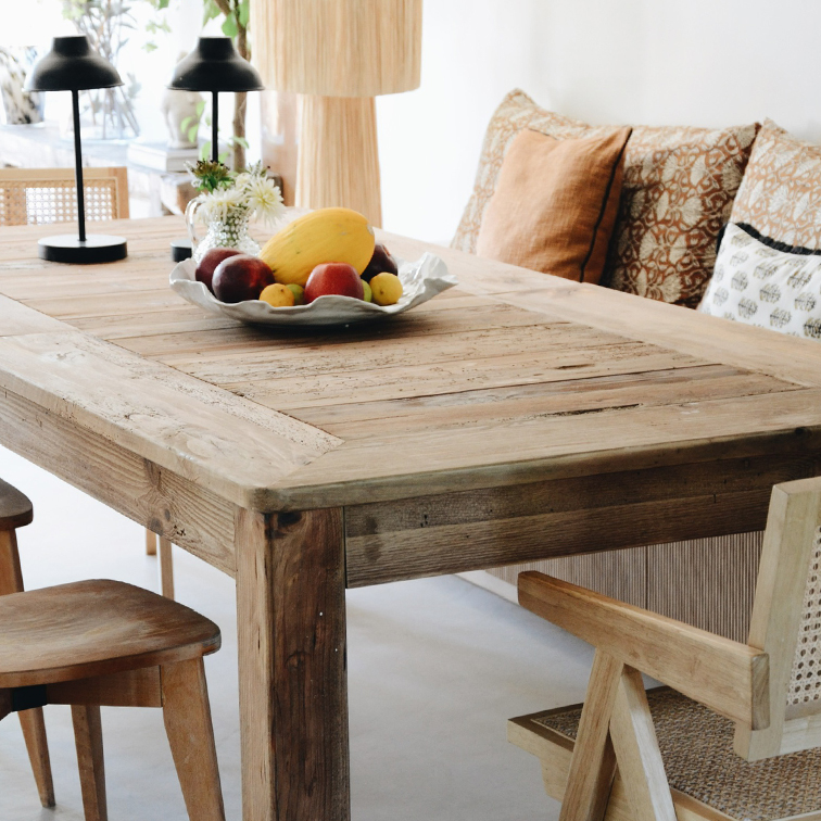 Rustieke houten eettafel met fruitschaal en tafellampen in lichte kamer