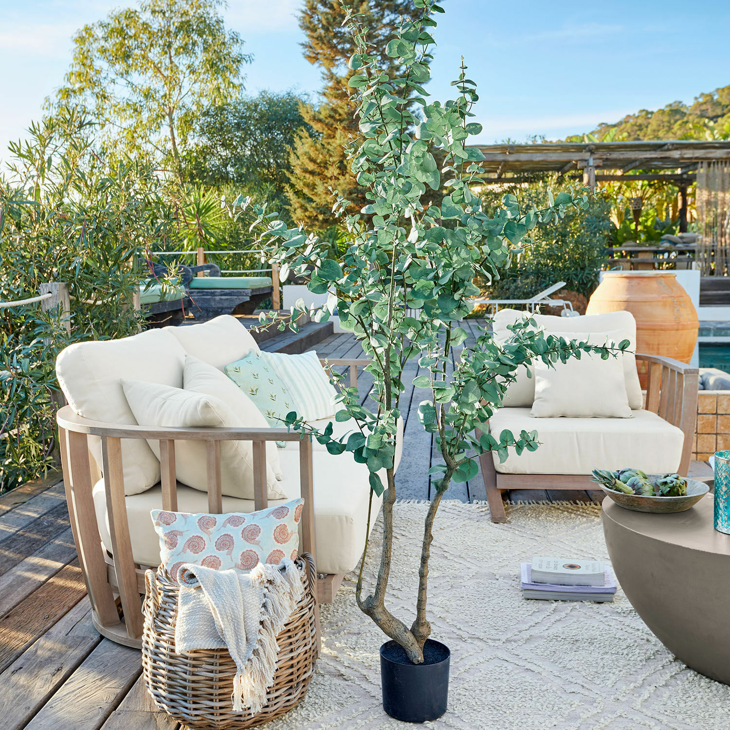 Decoratieve potplant Dorevi Grote kunstmatige eucalyptusplant in zwarte pot op terras met tuinmeubilair en decoraties