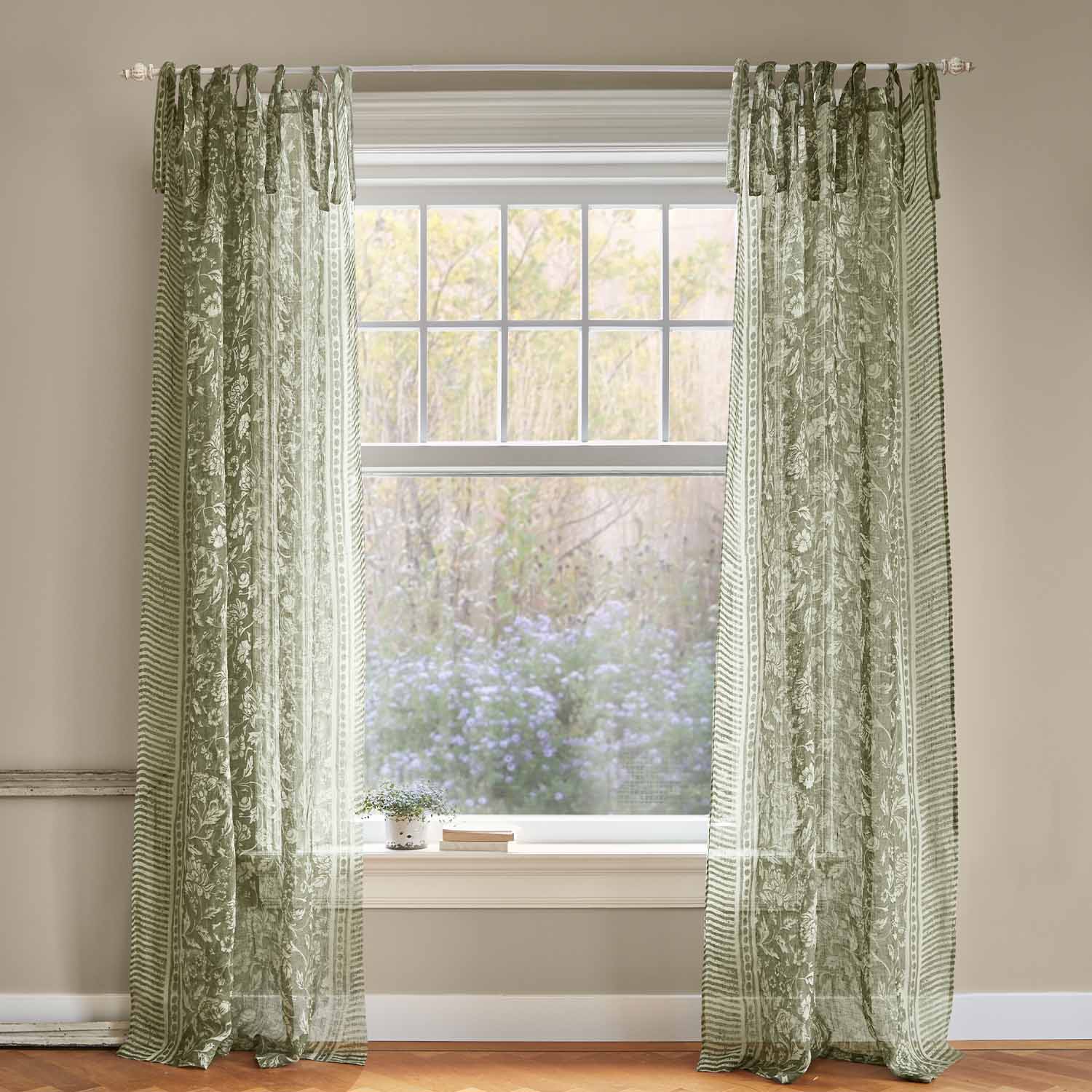 Groene, transparante gordijnen met bloemenpatroon aan het raam, lichte interieurdecoratie van stof.