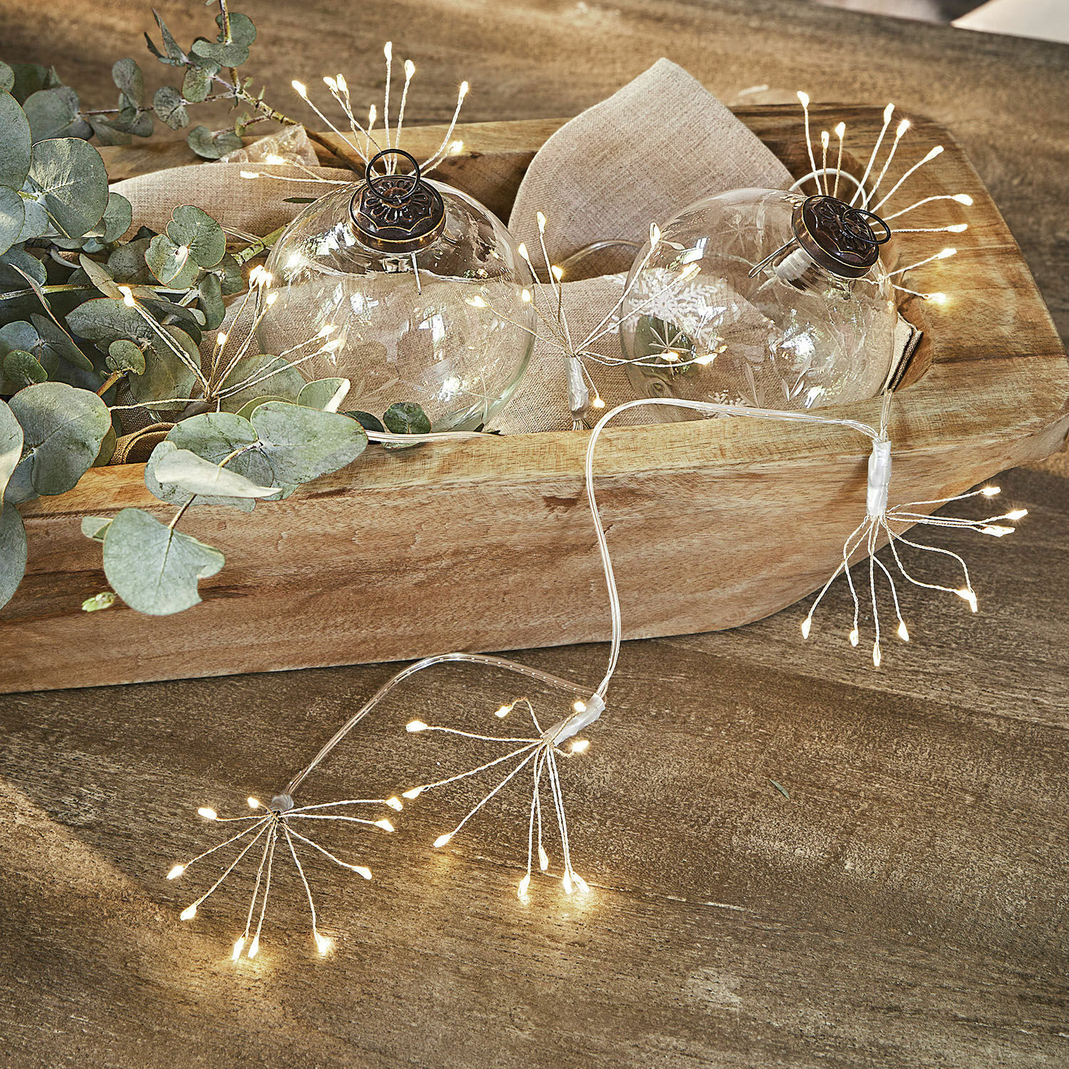 Lichtsnoer Sparkles Decoratieve glazen ballen met fijn patroon en warme LED-verlichting op houten dienblad