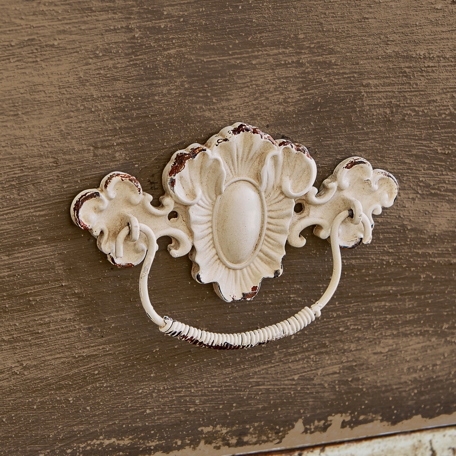 Verouderde witte metalen meubelgreep met decoratief patroon en ladegreep