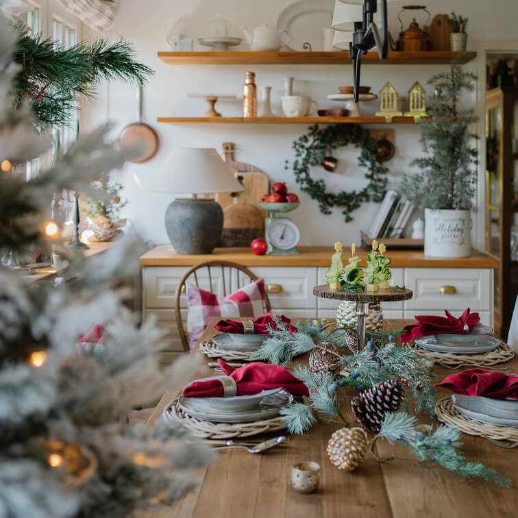 Houten tafel feestelijk gedekt met rode servetten en natuurlijke dennenappels en takken als decoratie