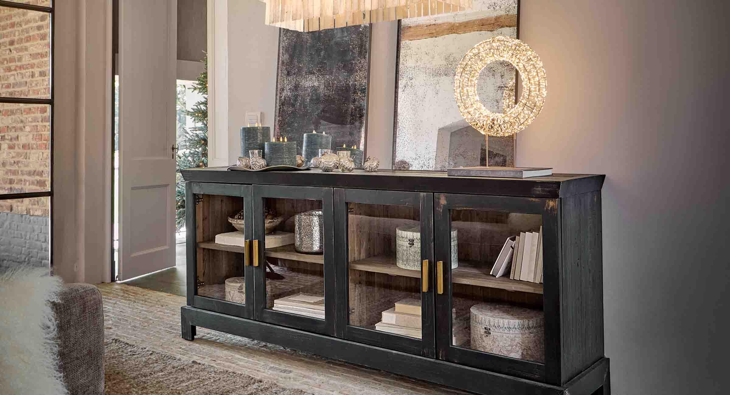Zwarte houten dressoir met glazen deuren en decoratieve kaarsen in stijlvolle woonkamer