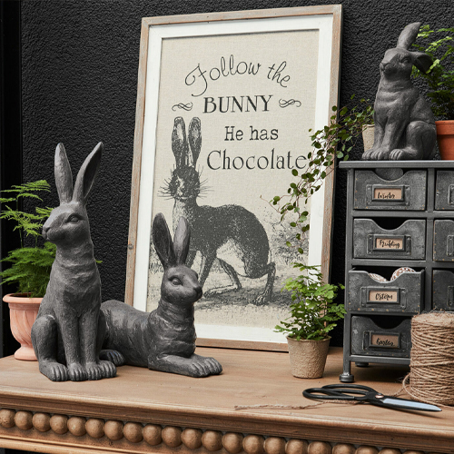 Grijze konijnenbeelden met tekst over chocolade in lijst, rustieke decoratie