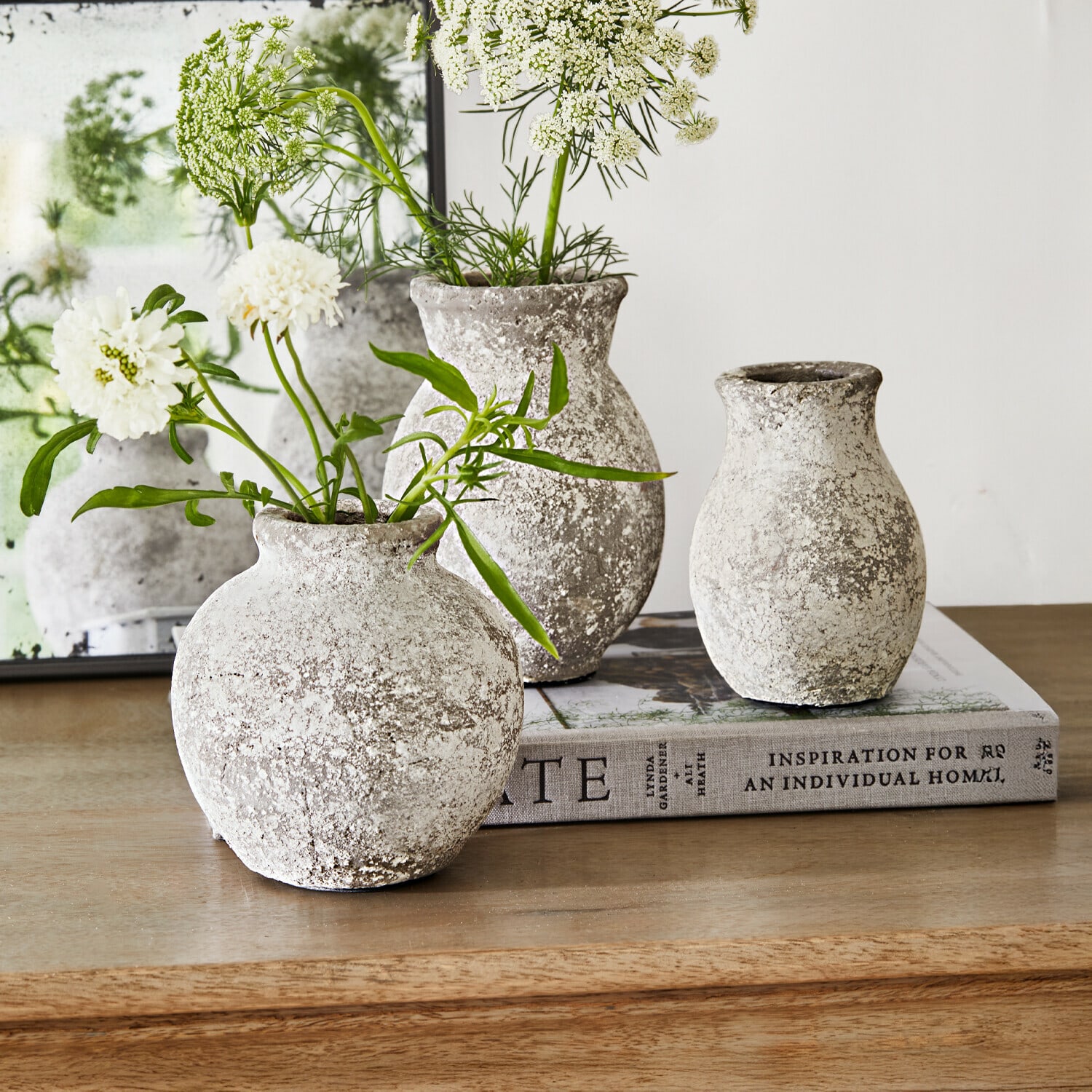 Vaas set van 3 Cerquix Drie rustieke stenen vazen in grijs-wit op houten tafel met witte bloemen