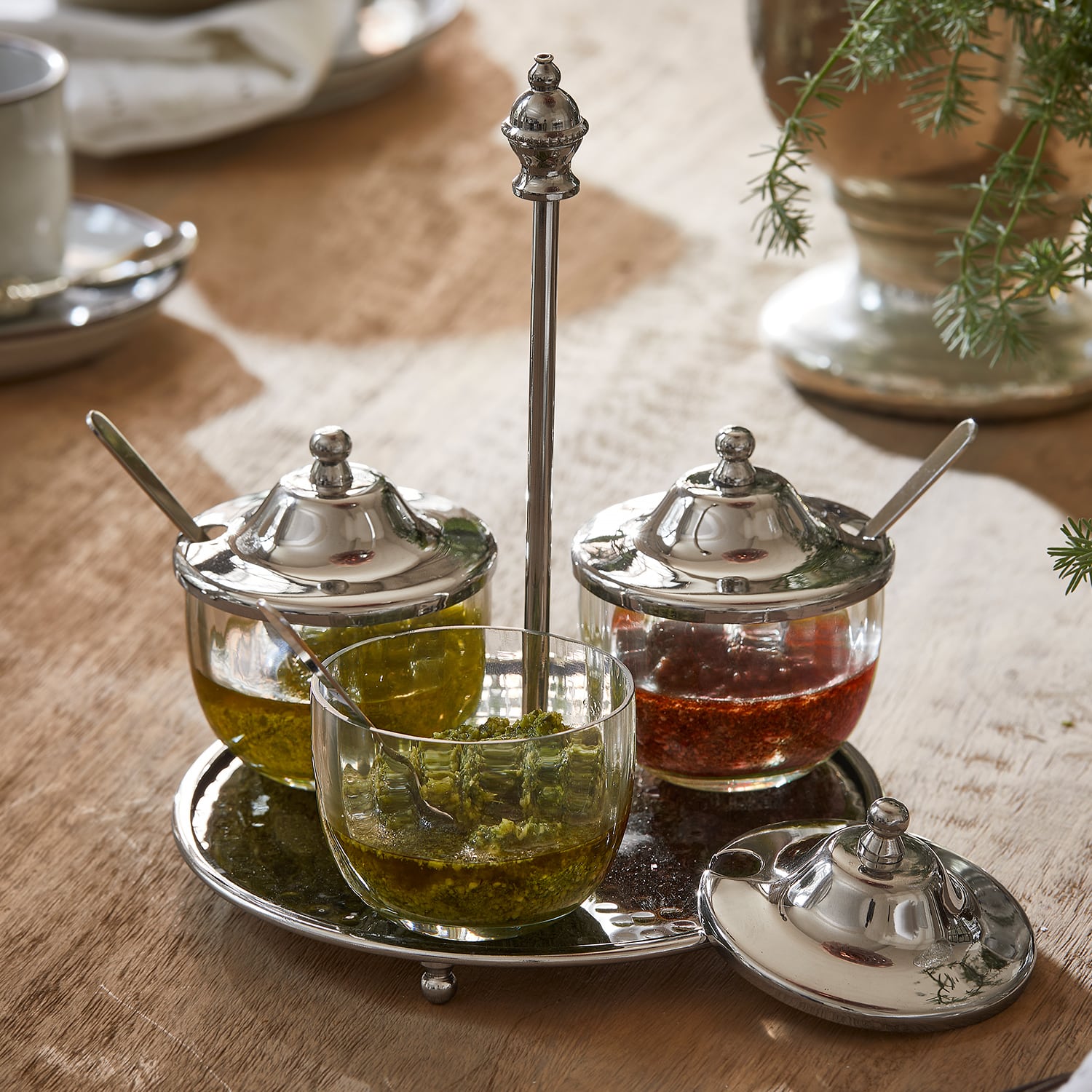 Set glazen kruidenpotjes met metalen deksels op metalen dienblad op houten tafel