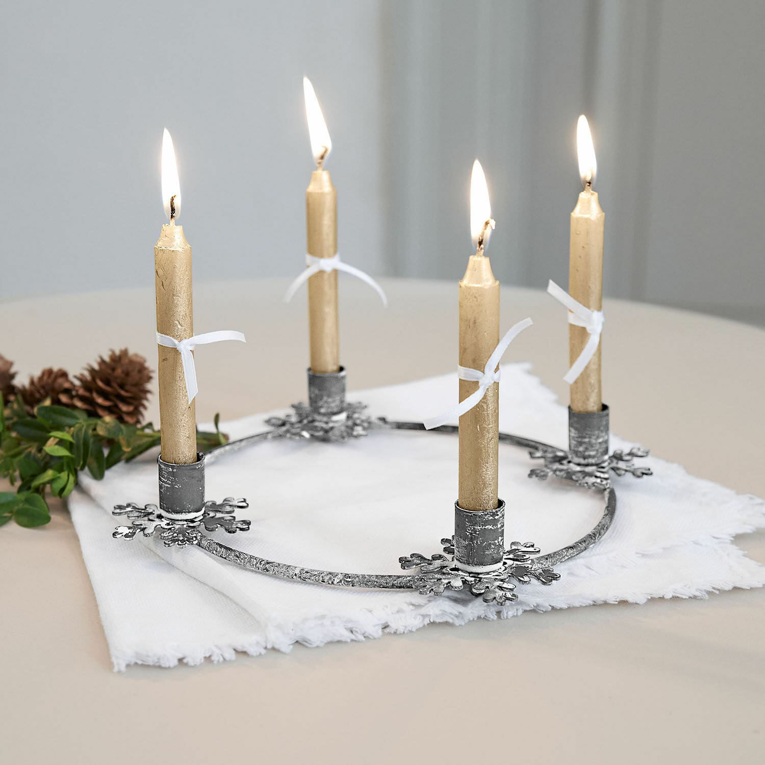 Kaarsenhouder Zarim Metalen adventskrans met vier gouden kaarsen op witte stof, kerstdecoratie