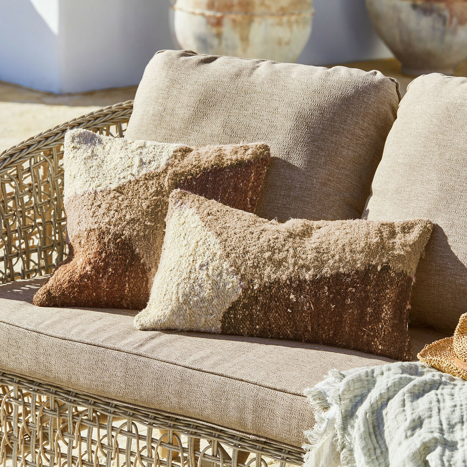 Kussenhoes set van 2 Everholt Beige rotanbank met zachte kussens in bruin- en crèmekleuren, decoratief textieldeken
