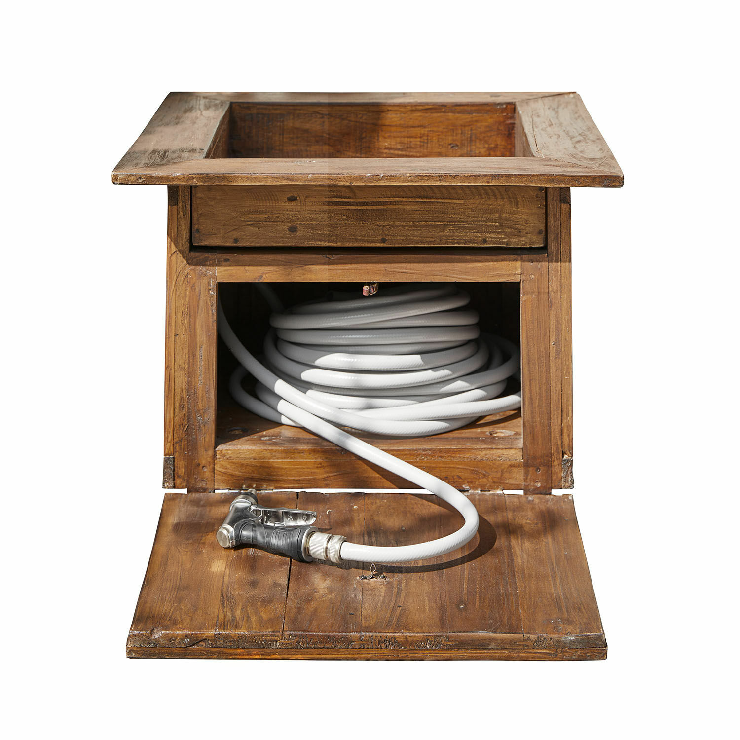 Houten kist met open deur en witte tuinslang opgerold binnenin, natuurlijke houtkleur