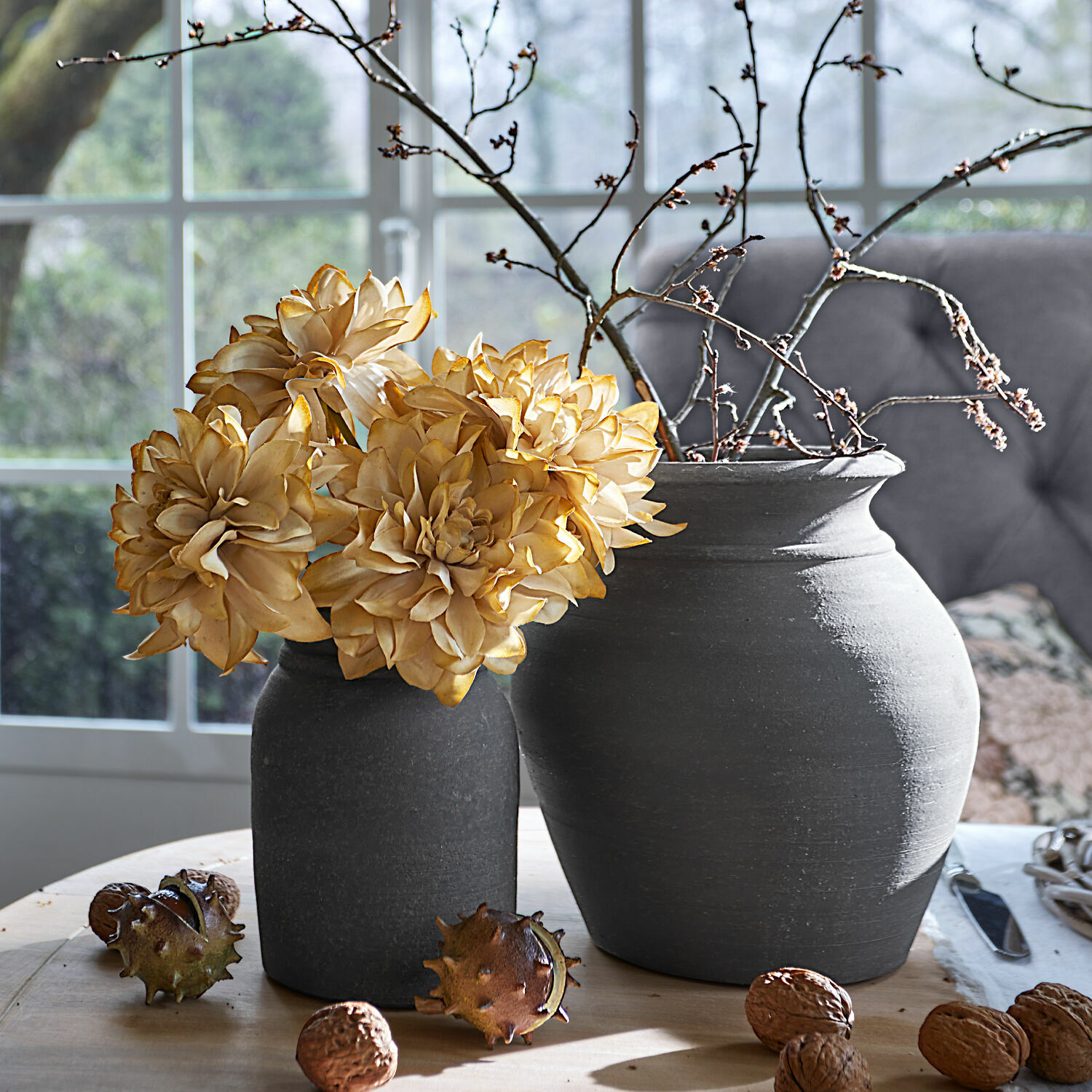 Vaas set van 2 Molduc Twee grijze keramische vazen met gedroogde bloemen en takken op houten tafel met noten