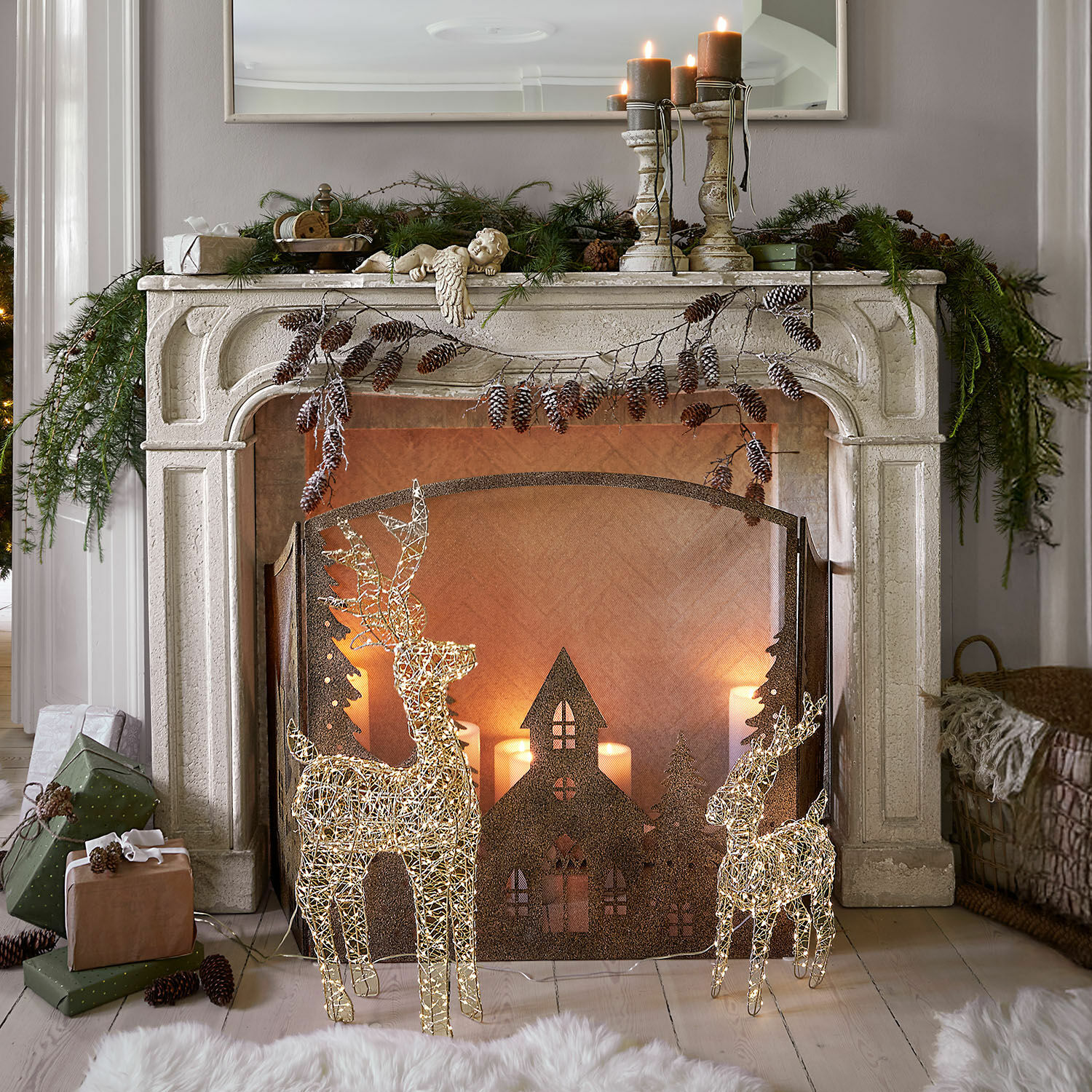 Haardschouw Woodcroft Decoratieve witte stenen open haard met verlichte rendieren en kerstkaarsen in gezellige woonkamer