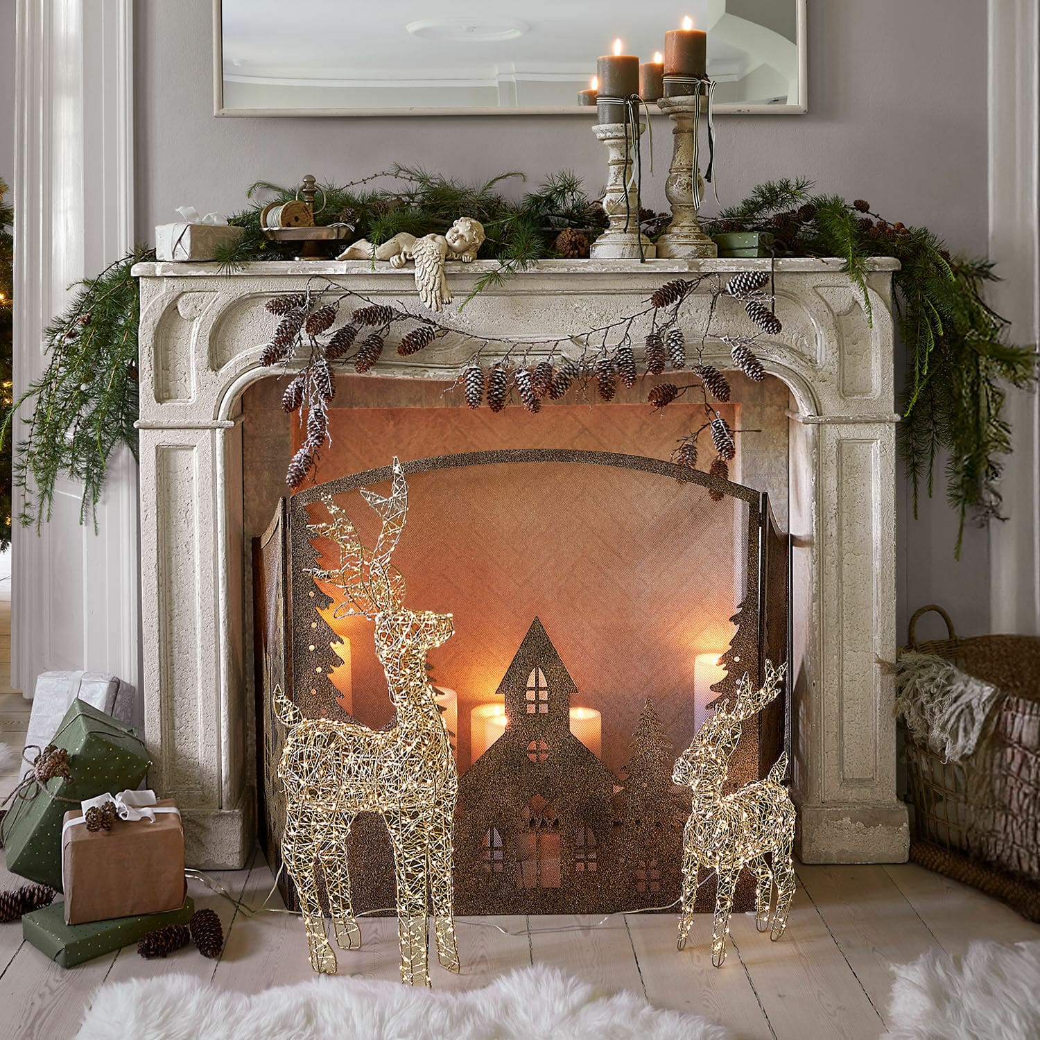 Haardschouw Woodcroft Decoratieve witte stenen open haard met verlichte rendieren en kerstkaarsen in gezellige woonkamer