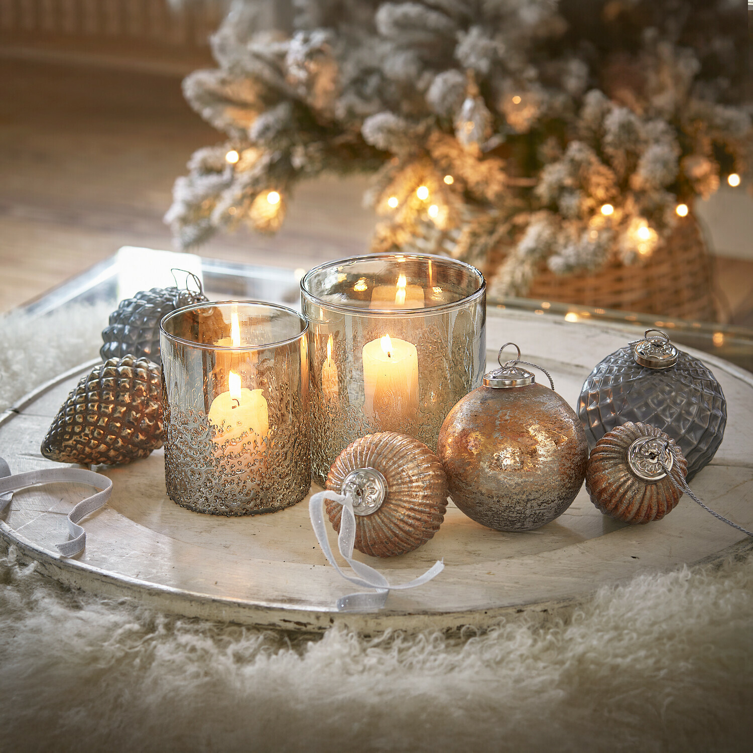 Decoratief dienblad met twee kaarsen in glazen houders en koperen metalen ornamenten