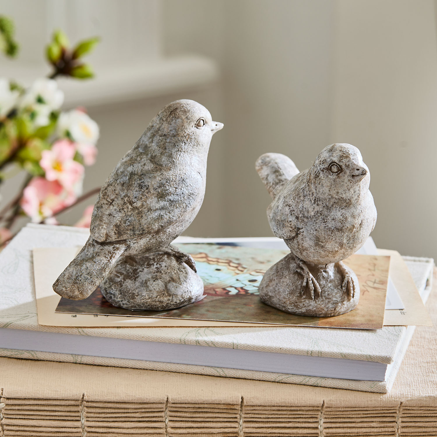Decoratieve grijze stenen vogels op boeken, stijlvolle woondecoratie en tafeldecoratie
