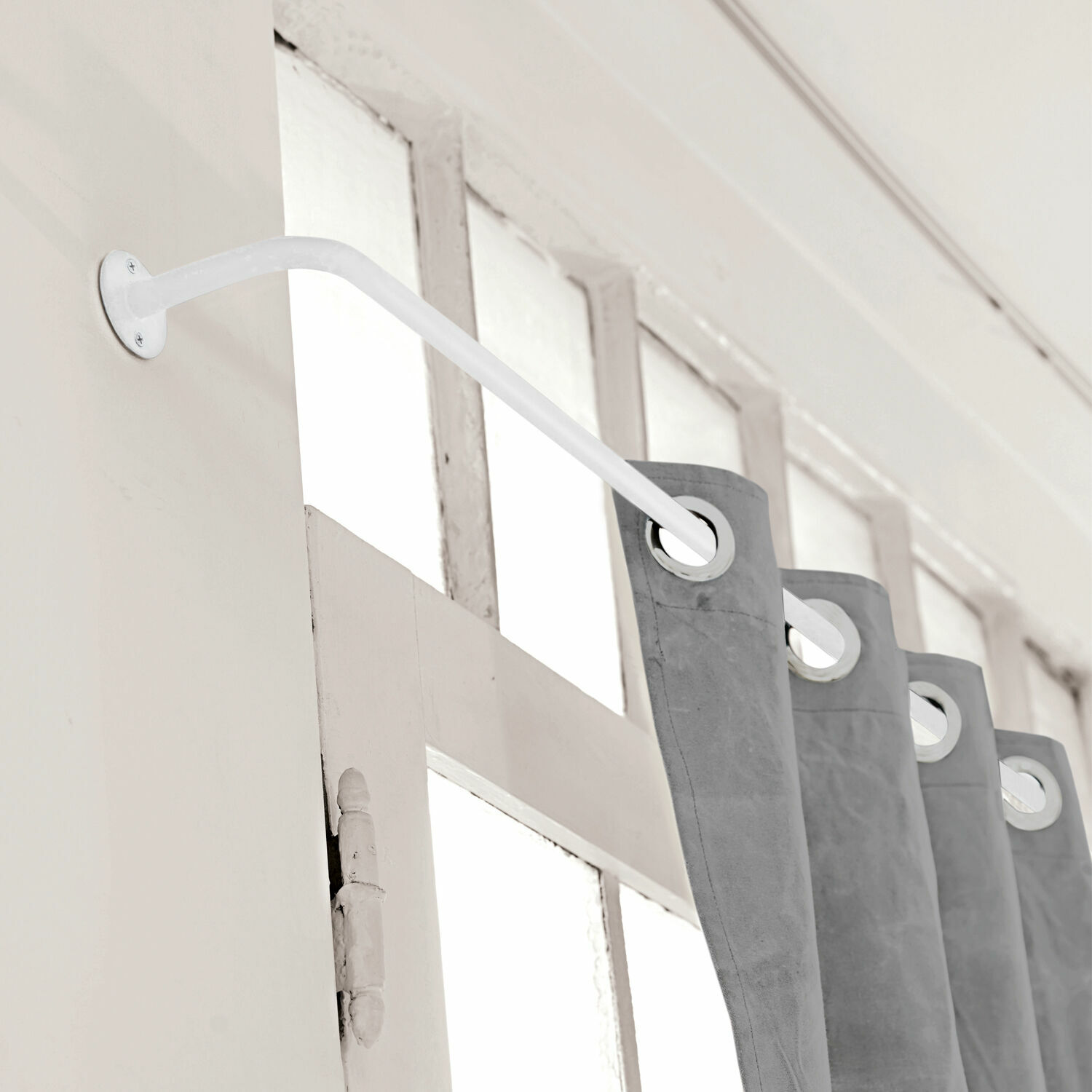 Gordijnroede Omara Witte metalen gordijnroede aan de muur met grijze gordijnen met ringen