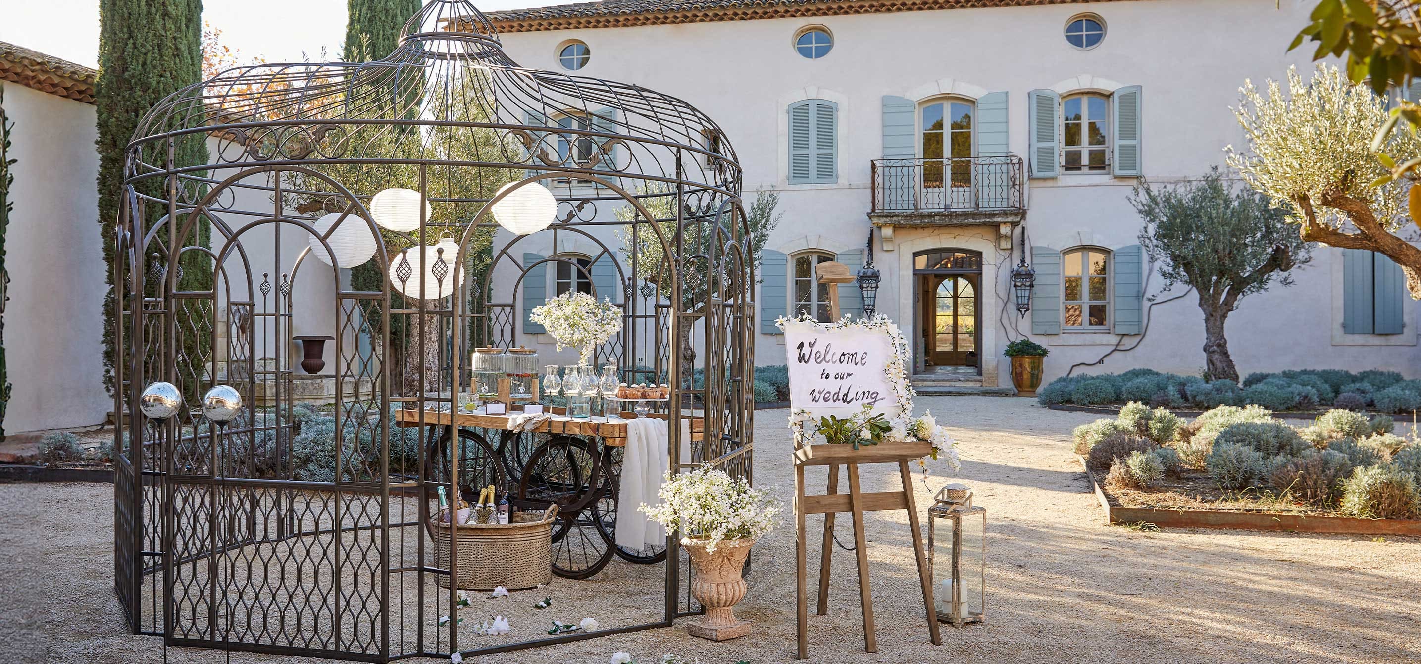 Vintage metalen tuinpaviljoen met bruiloftdecoratie en houten ezel met welkomstbord