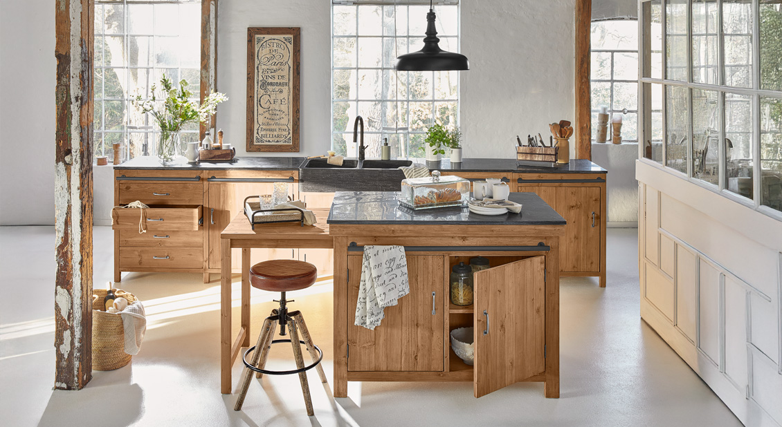 Landelijke keuken met houten kasten en zwart werkblad in natuurlijk ochtendlicht