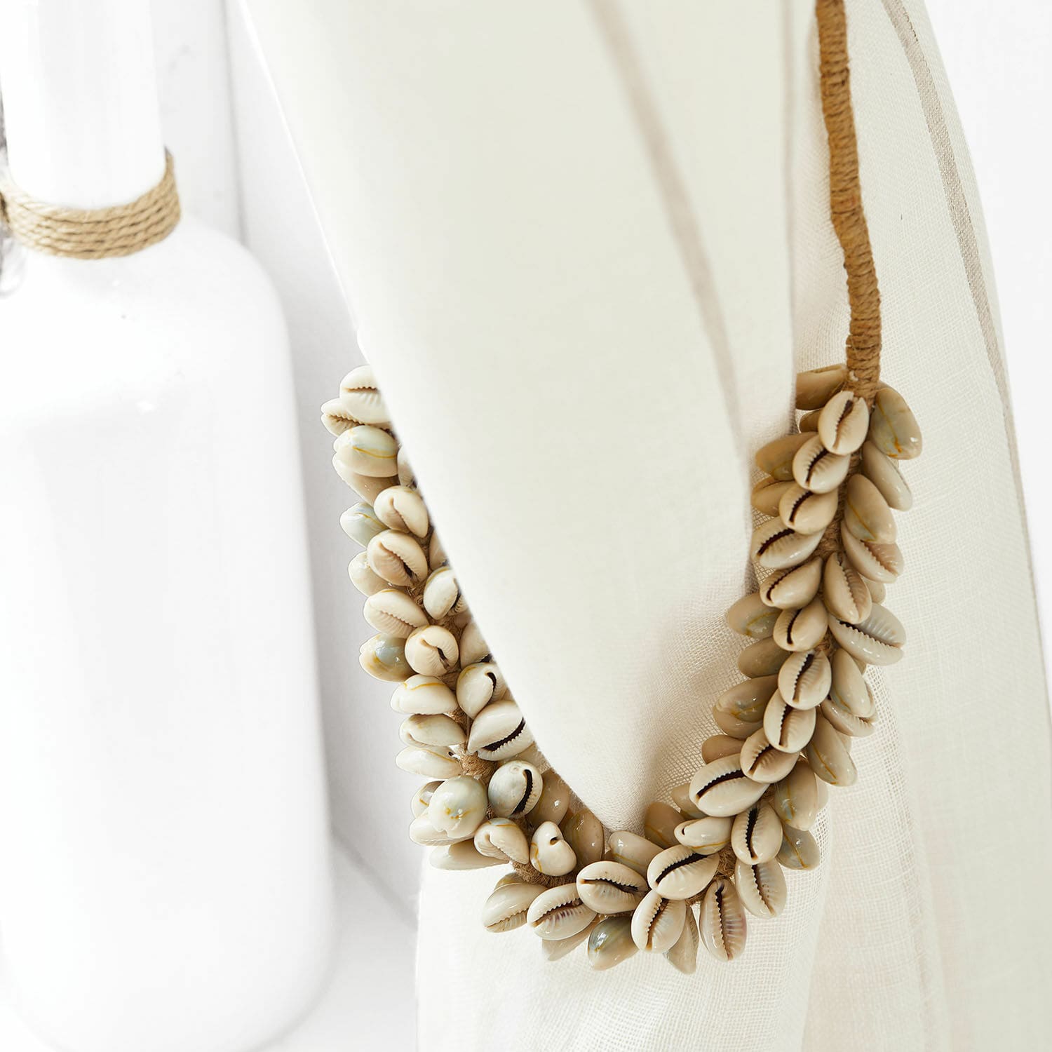 Decoratieve krans van natuurlijke schelpen in beige tinten op linnen stof