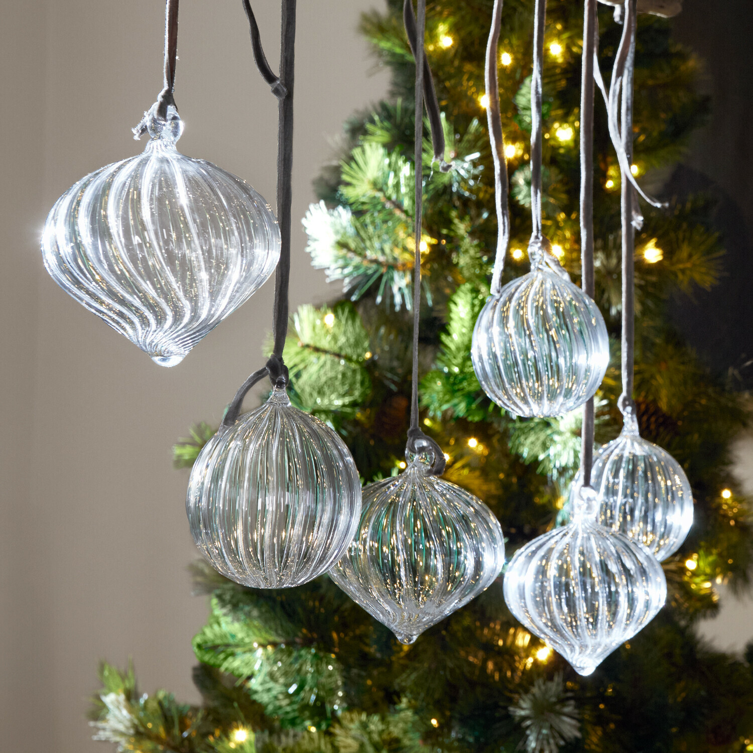 Kerstbal set van 6 Bavella Transparante glazen kerstballen met groeven hangend voor een verlichte kerstboom