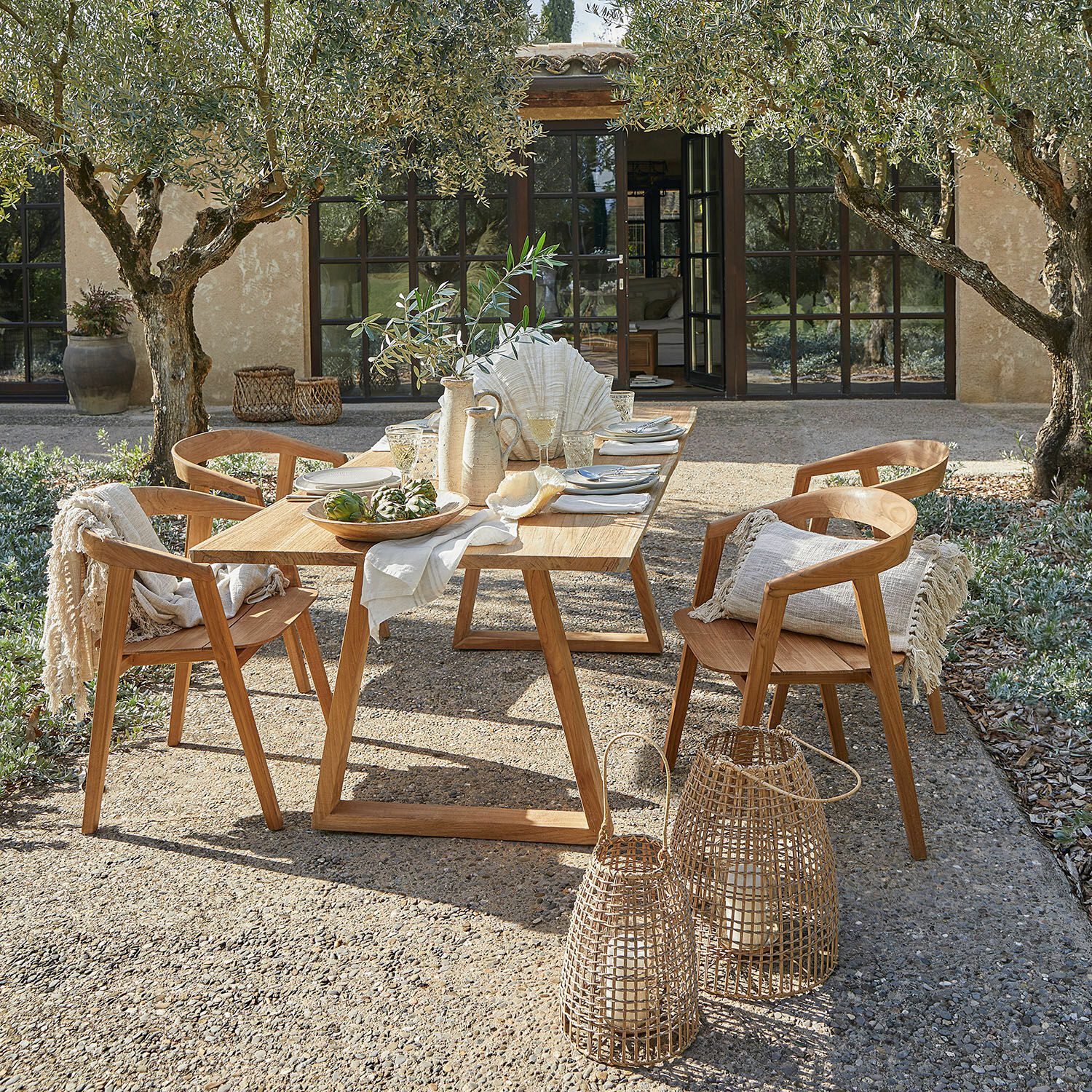 Tafel Saulny Tuinmeubelset van natuurlijk teakhout met decoraties en lantaarns op zonnig terras