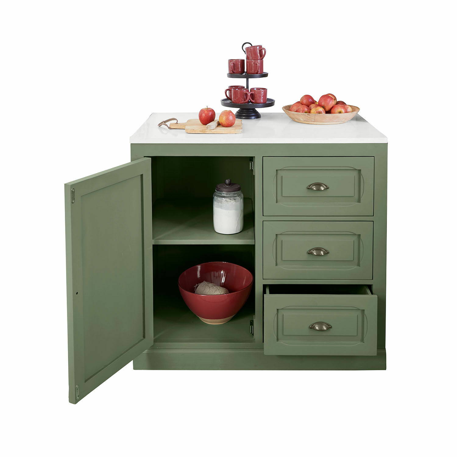 Groene keukenkast met wit blad, open deur en lades, rood servies en appels erop