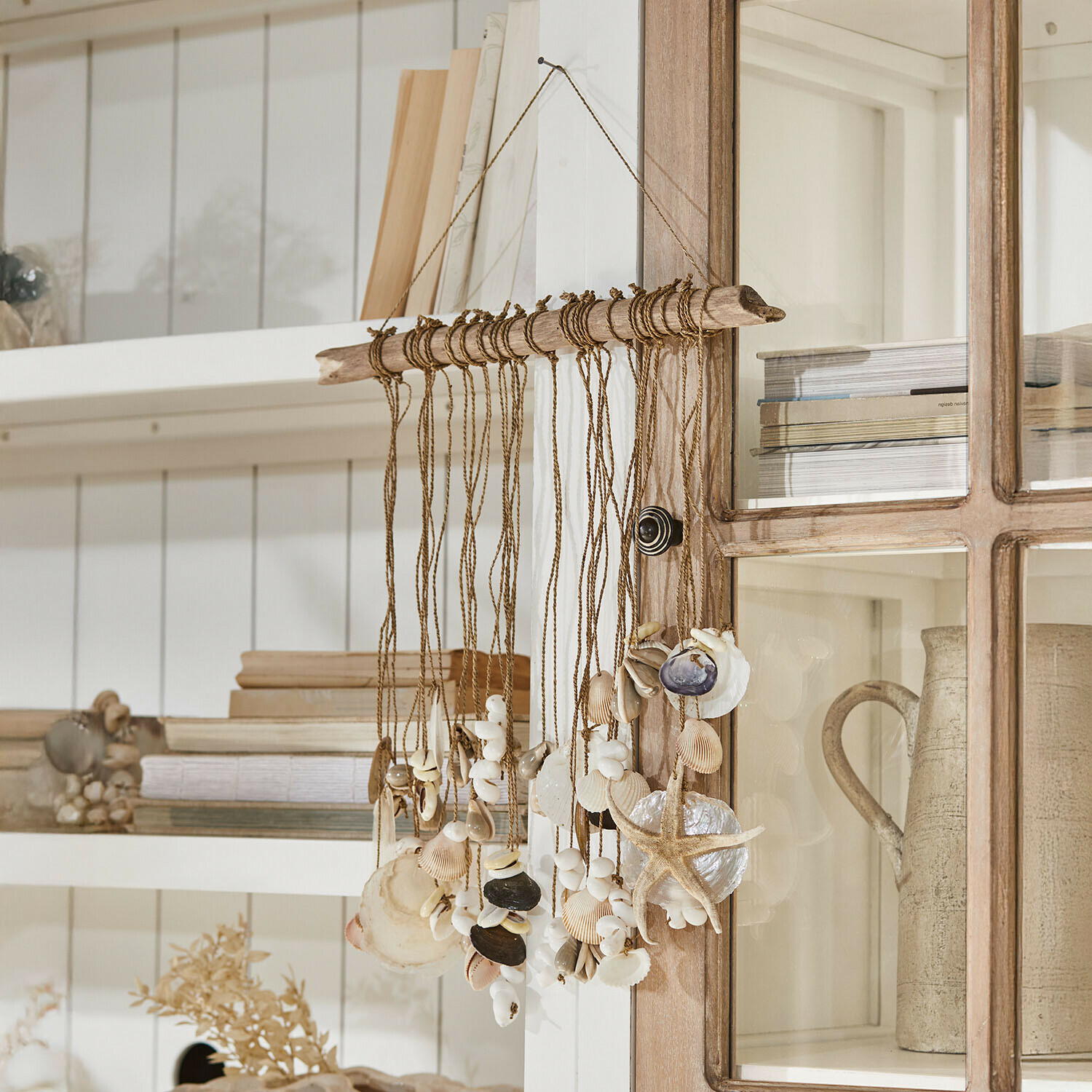 Hangende decoratie van schelpen en zeester aan touw met drijfhout, natuurlijke kleuren, wandversiering