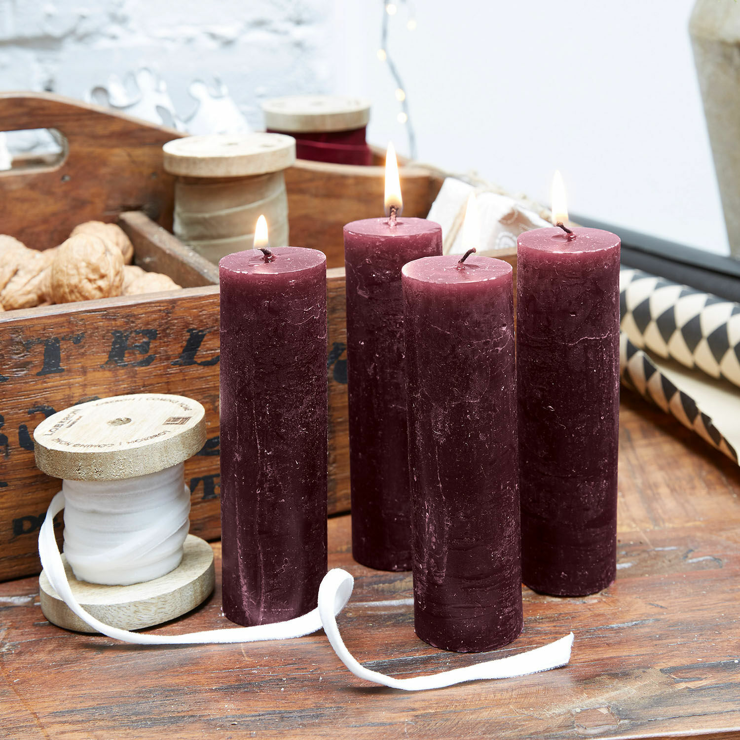 Kaars set van 4 Muriel Vier bordeauxkleurige waskaarsen op houten tafel met decoratief lint en noten
