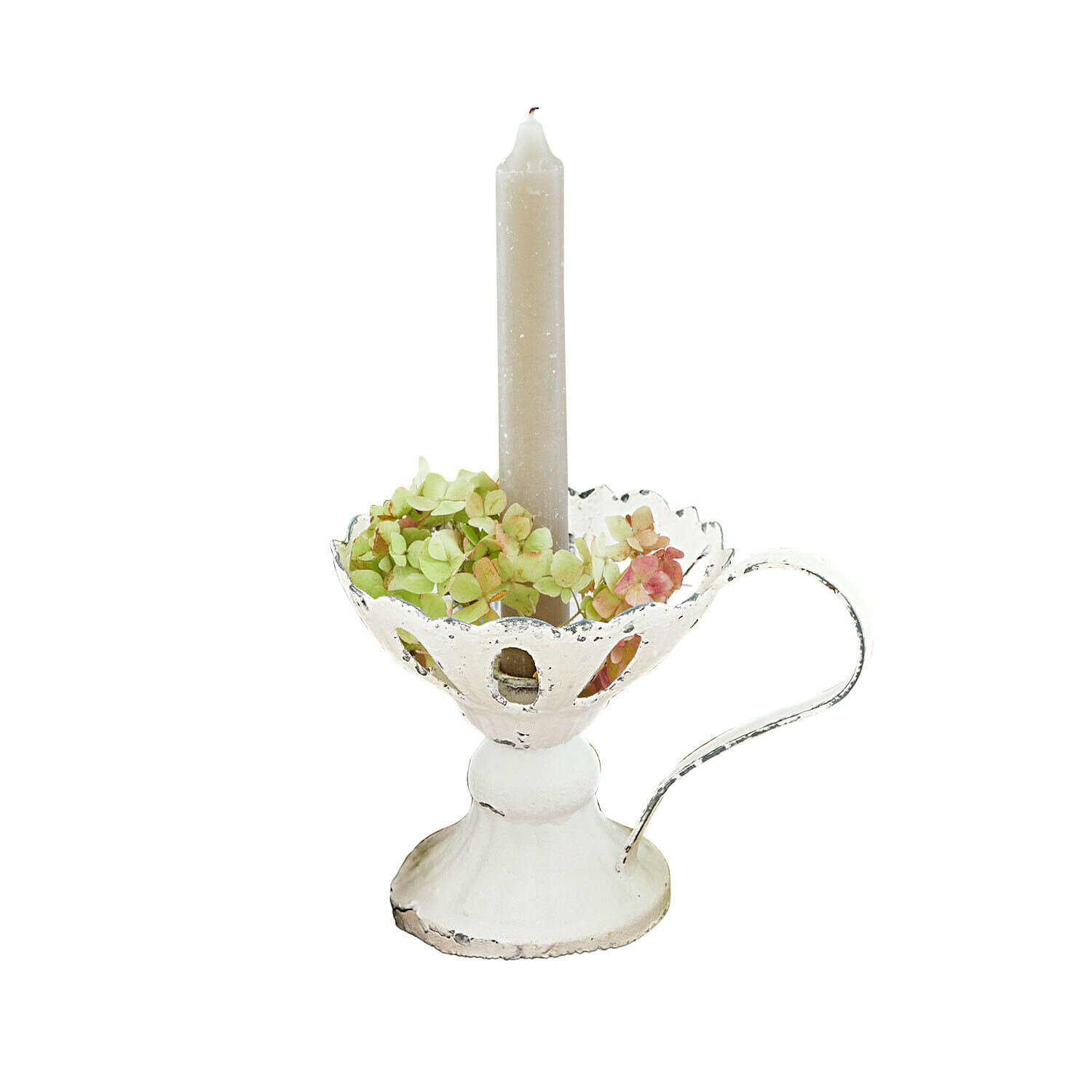 Witte metalen kandelaar met handvat, beige kaars en groene en roze bloemen als decoratie