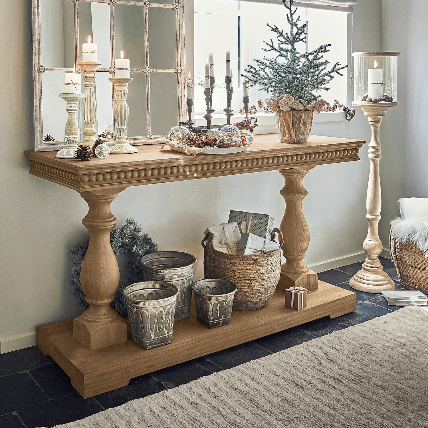 Houten sidetable met decoratieve kandelaars en kerstdecoratie in lichte kamer
