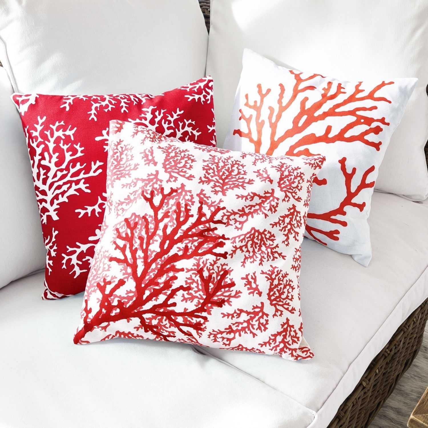 Kussenhoes set van 3 Colourful Drie decoratieve kussens met rood koraalpatroon op witte stof op een lichte bank