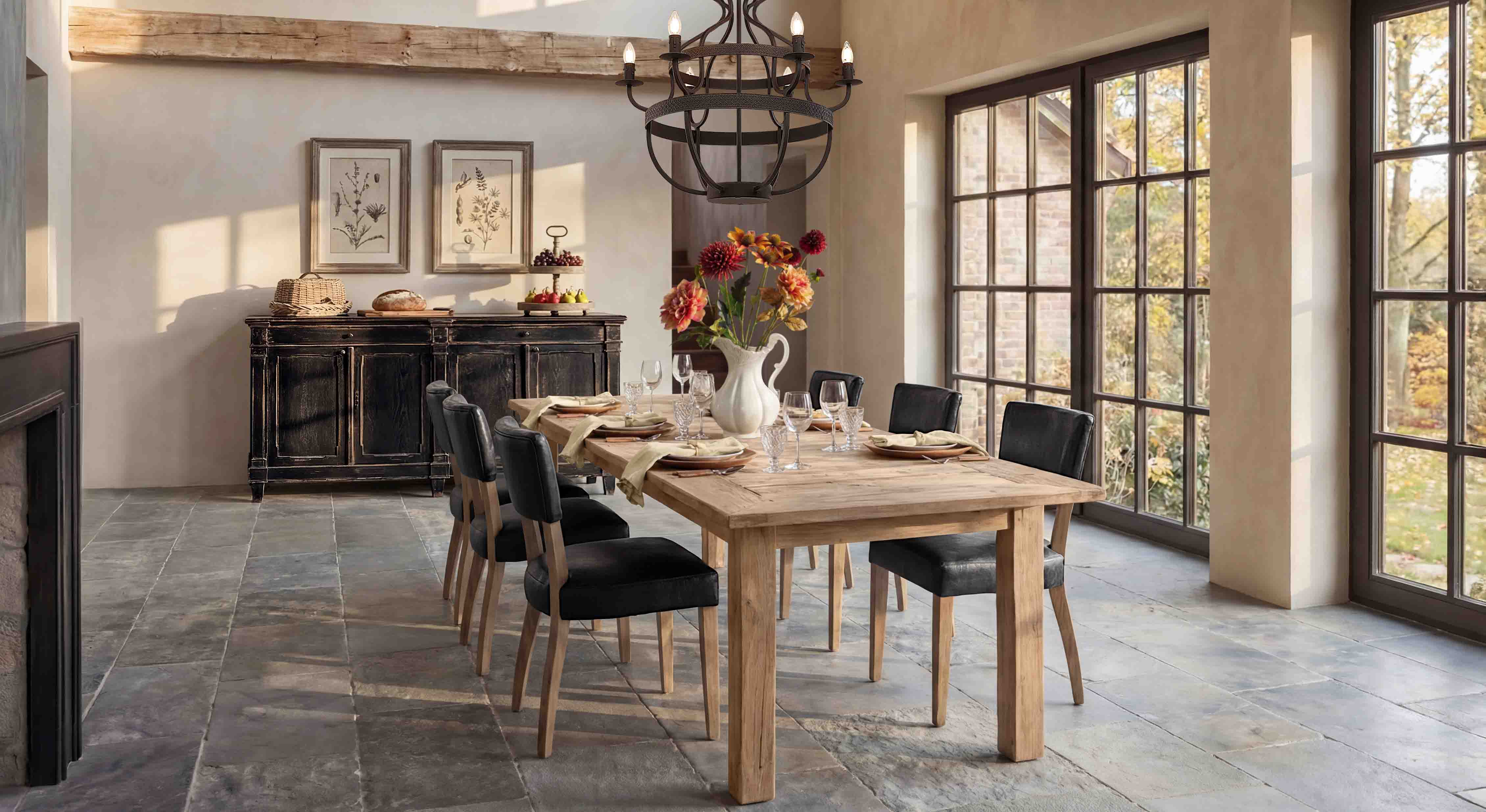 Eetkamer met lichte houten tafel en zwarte stoelen, veel natuurlijk licht door grote ramen