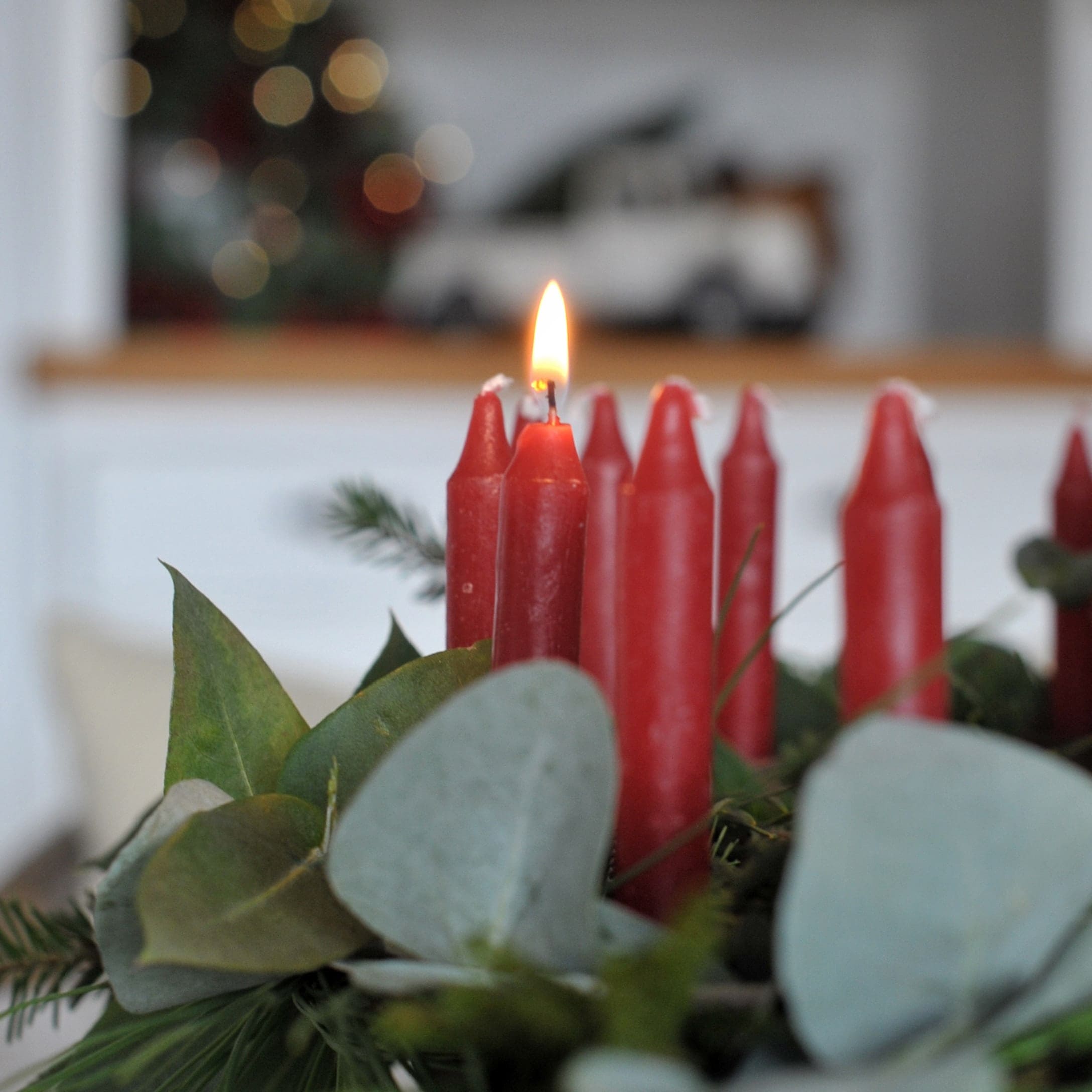 Rode adventskaarsen met groene bladeren als feestelijke kerstdecoratie