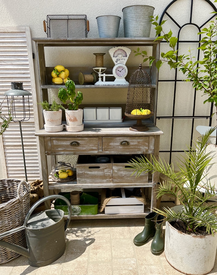 Rustieke houten kast met planken en lades in vintage stijl, tuindecoratie op zonnig terras