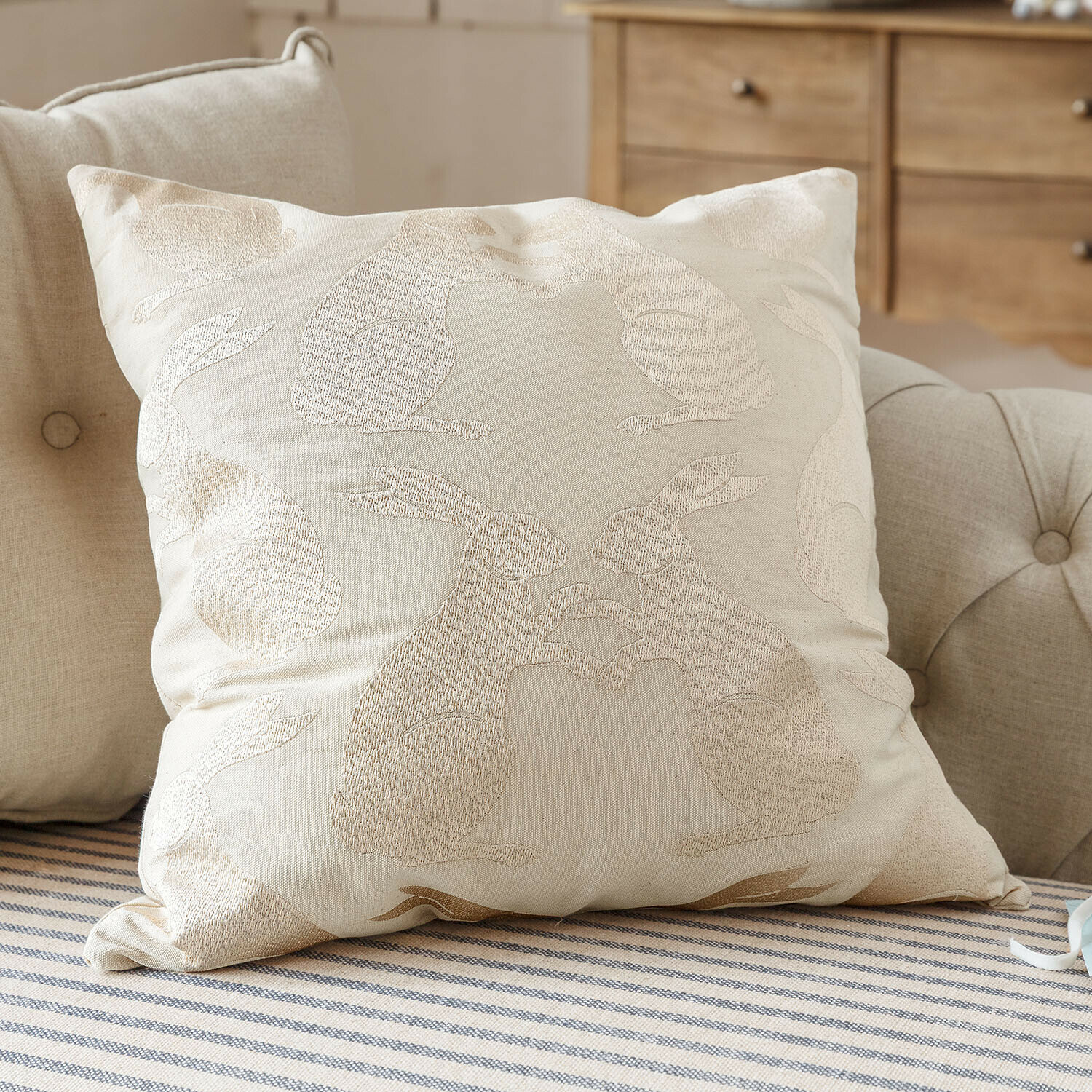 Beige katoenen sierkussen met geborduurd konijnenpatroon, zacht en stijlvol voor de woonkamer