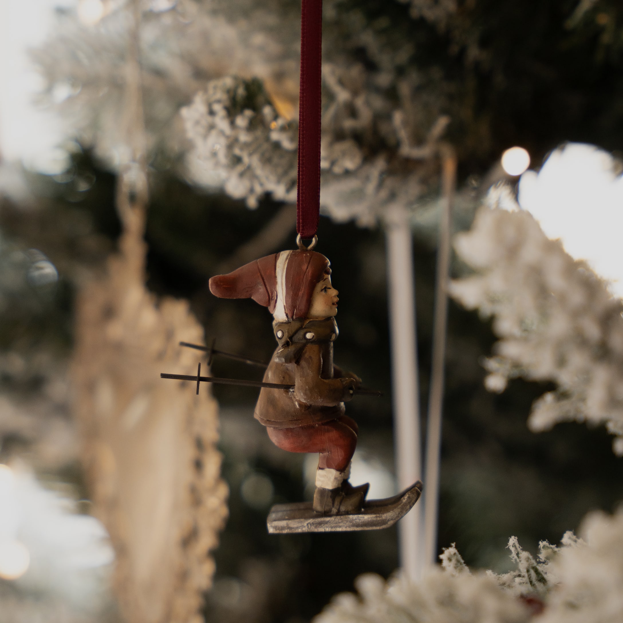 Kerstversiering met skiërsfiguur in rode kleding, hangend aan boom, winterse decoratie