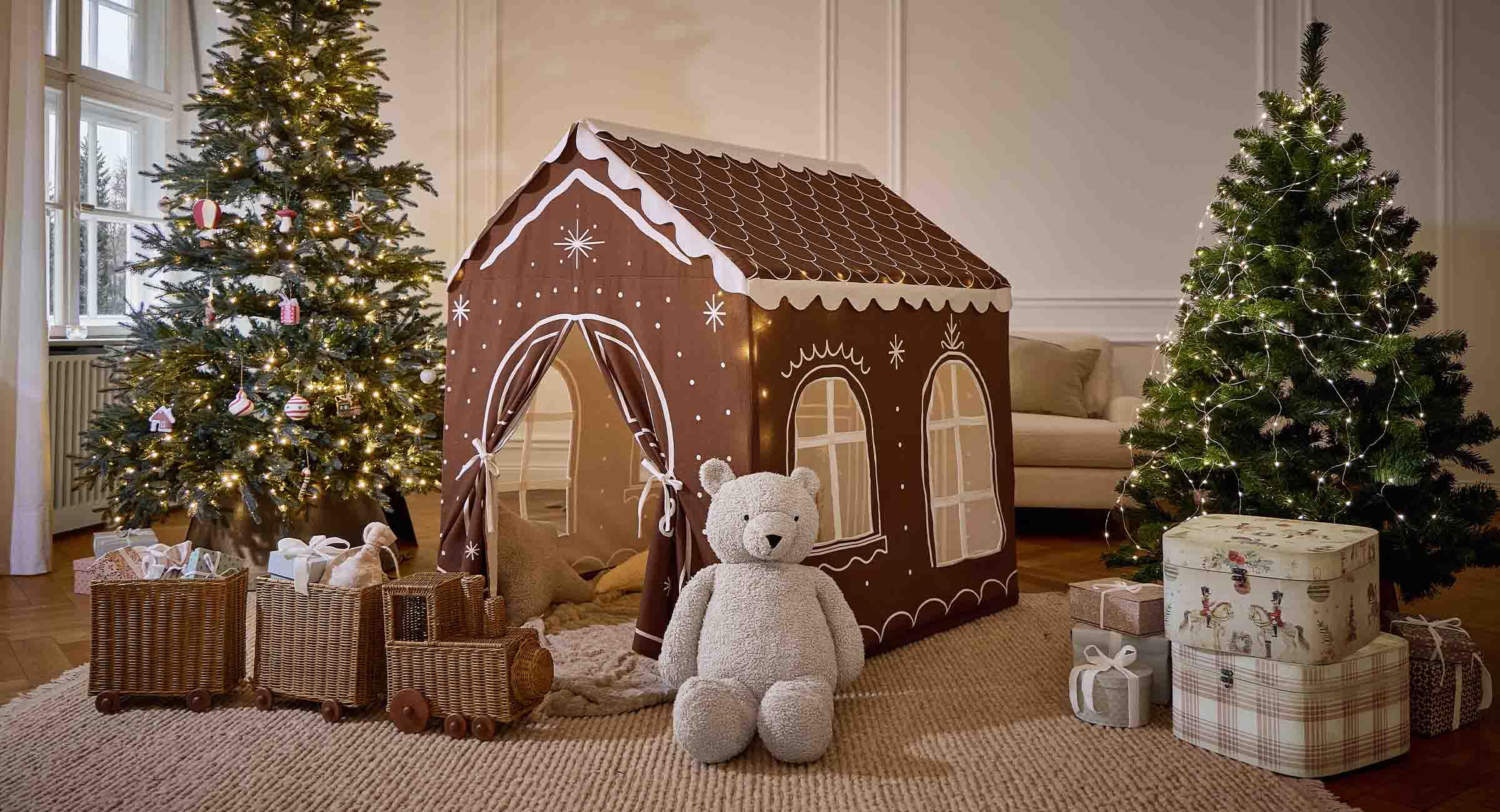 Bruine kinderspeeltent in de vorm van een peperkoekhuisje met witte patronen, pluche beer en kerstdecoratie