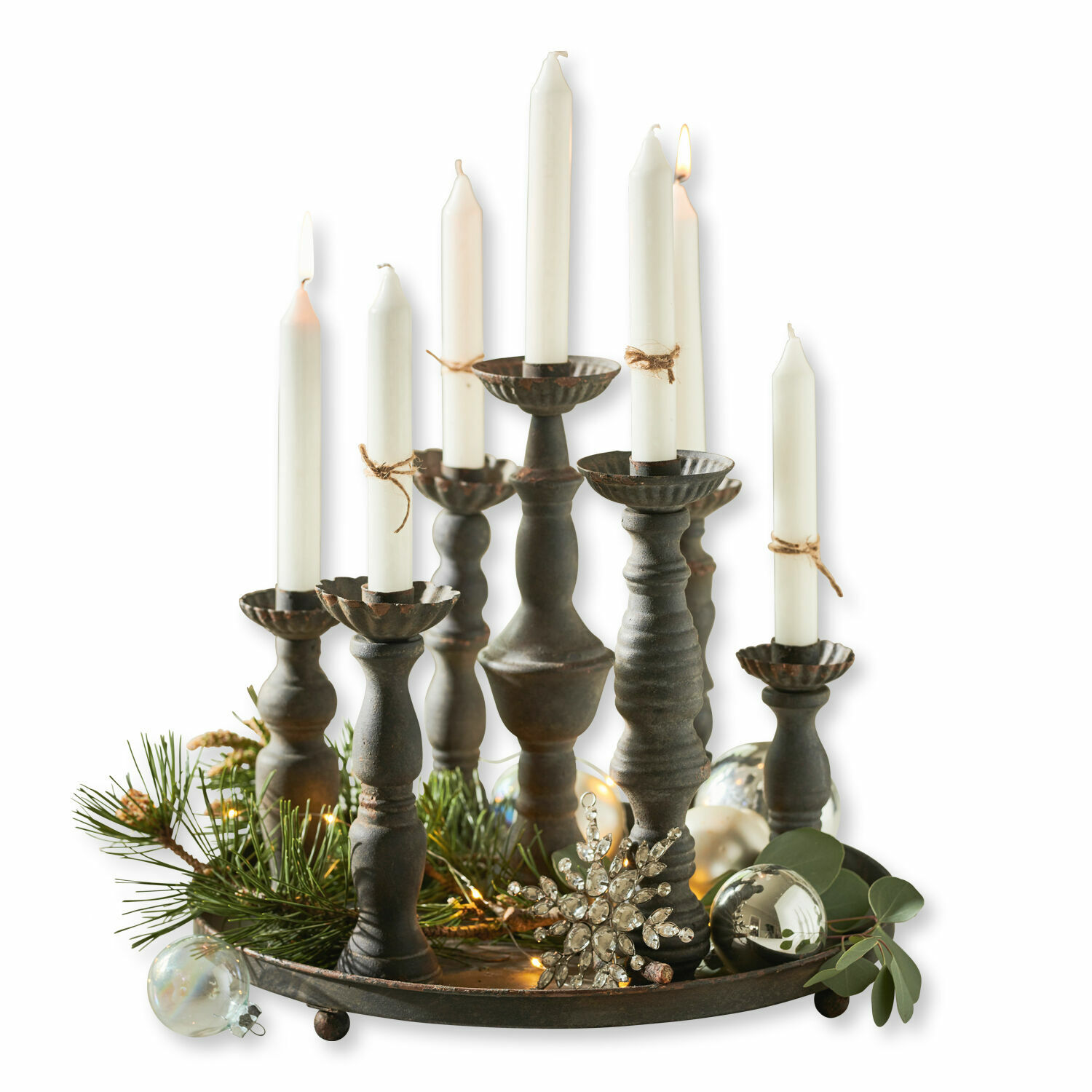 Metalen kandelaar met witte kaarsen en kerstdecoratie van takken en ballen