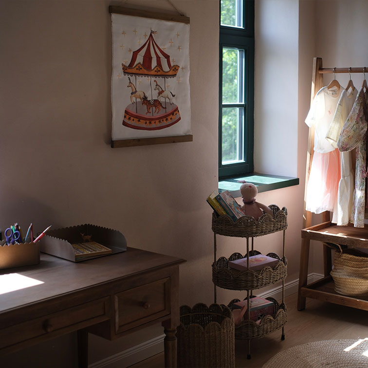 Gezellige kinderkamer met houten bureau, rieten rek en wanddecoratie met carrousel
