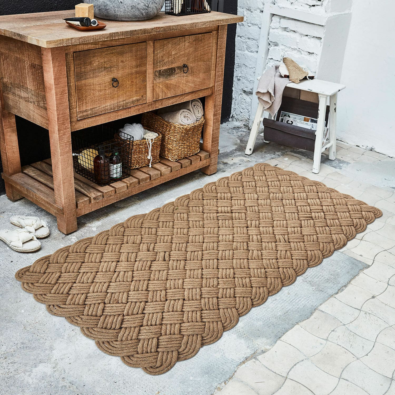 Loper Hildas Bruin vloerkleed van gevlochten touw naast een houten kast en een witte kruk