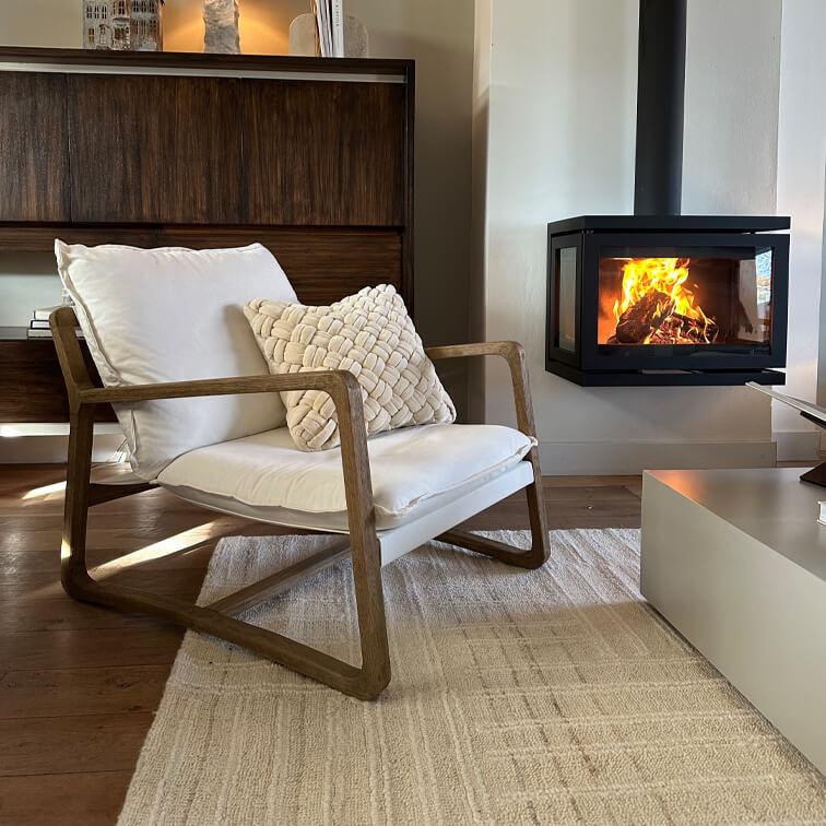 Houten stoel met wit kussen naast moderne haard in gezellige woonkamer