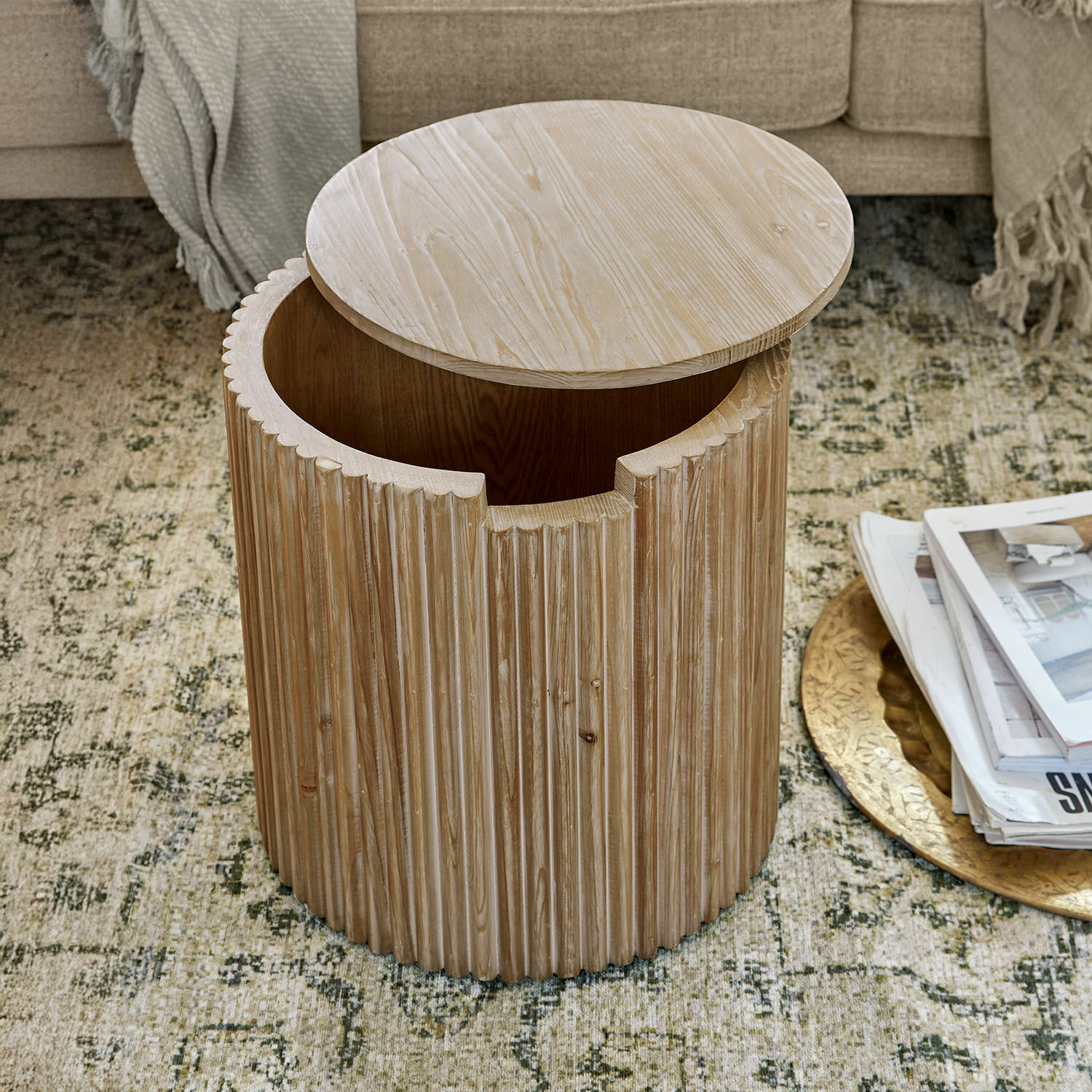 Ronde bijzettafel van licht hout met geribbelde afwerking en praktische opbergruimte voor woonkamer