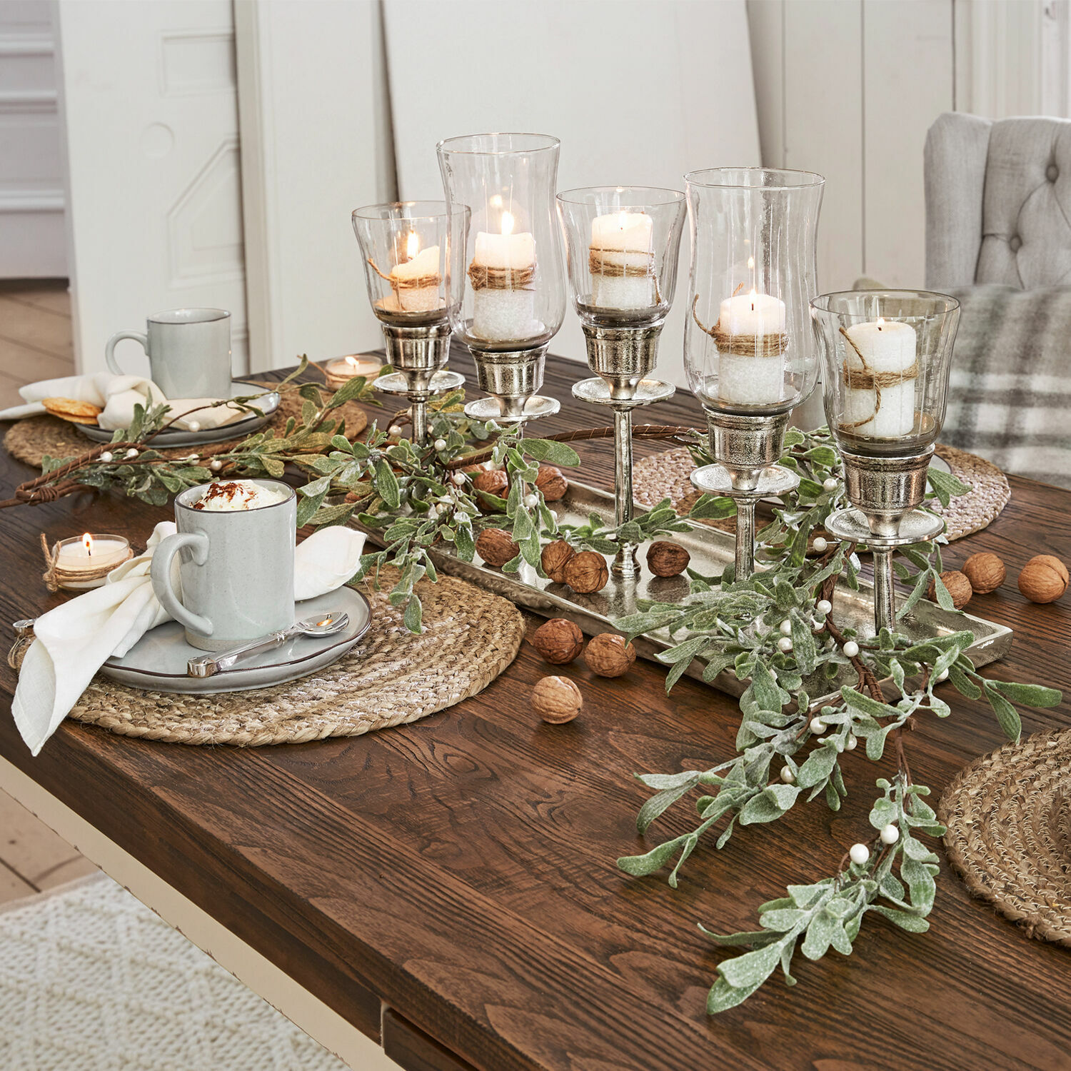 Guirlande Cunnig Decoratieve set glazen en metalen kandelaars op houten tafel met groene takken en noten