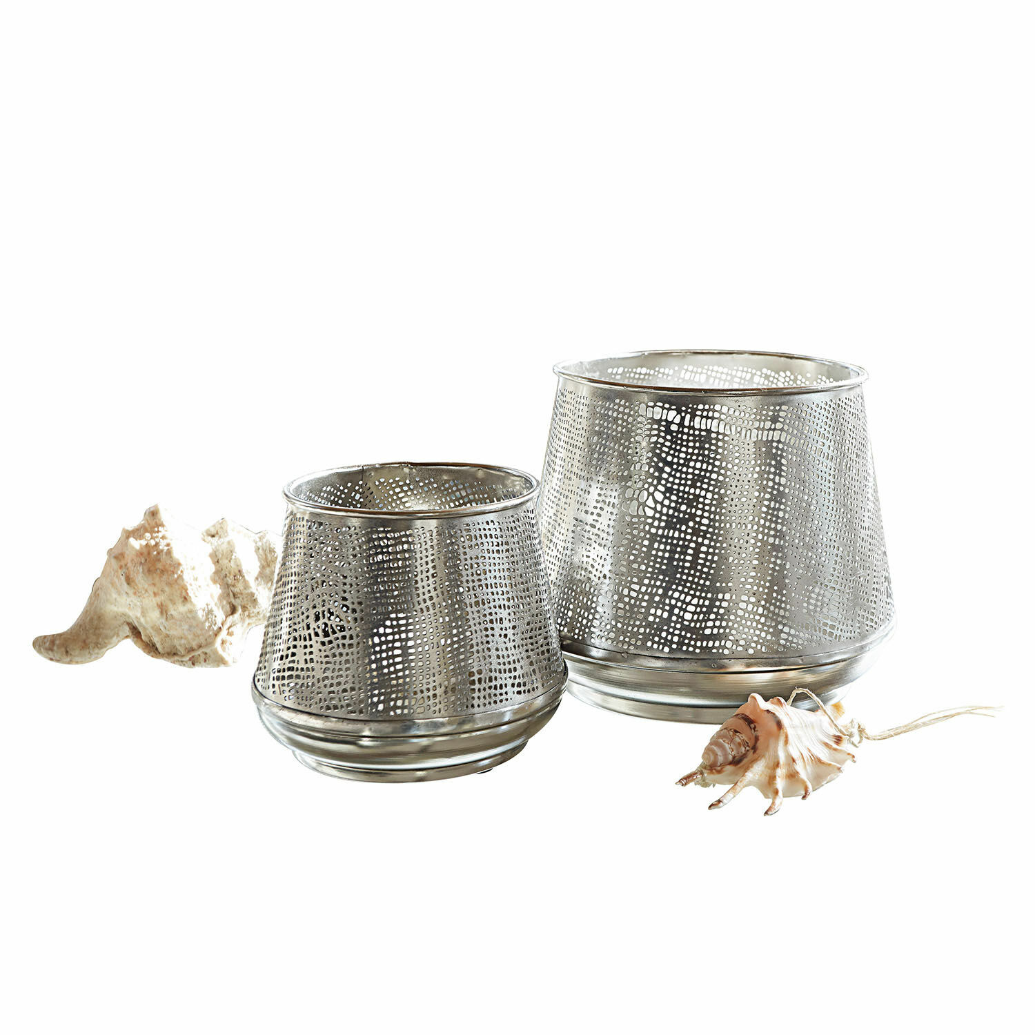 Twee zilverkleurige metalen windlichten met geperforeerd patroon en decoratieve schelpen op witte achtergrond