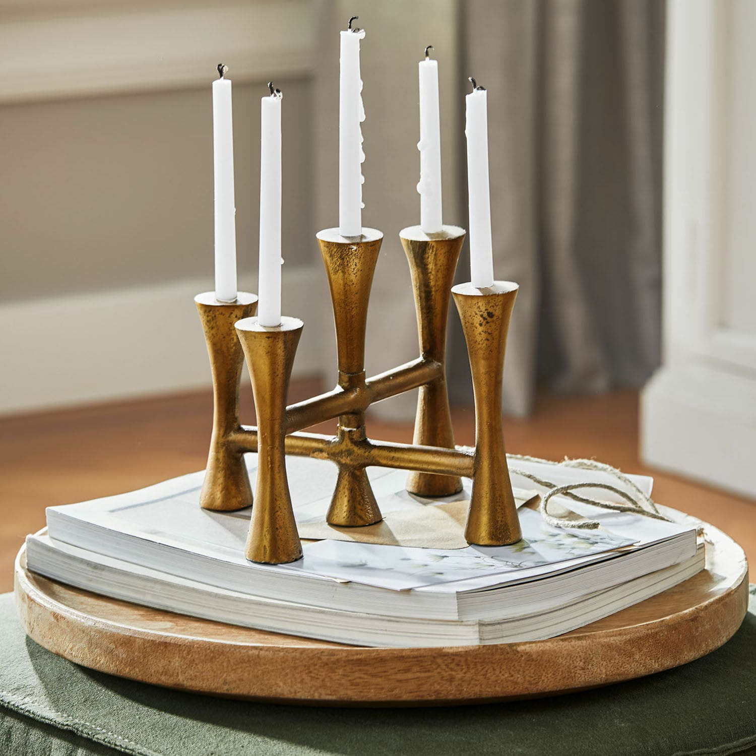 Kandelaar Feroze Gouden metalen kandelaar voor vijf witte kaarsen op houten dienblad met boeken, interieurdecoratie