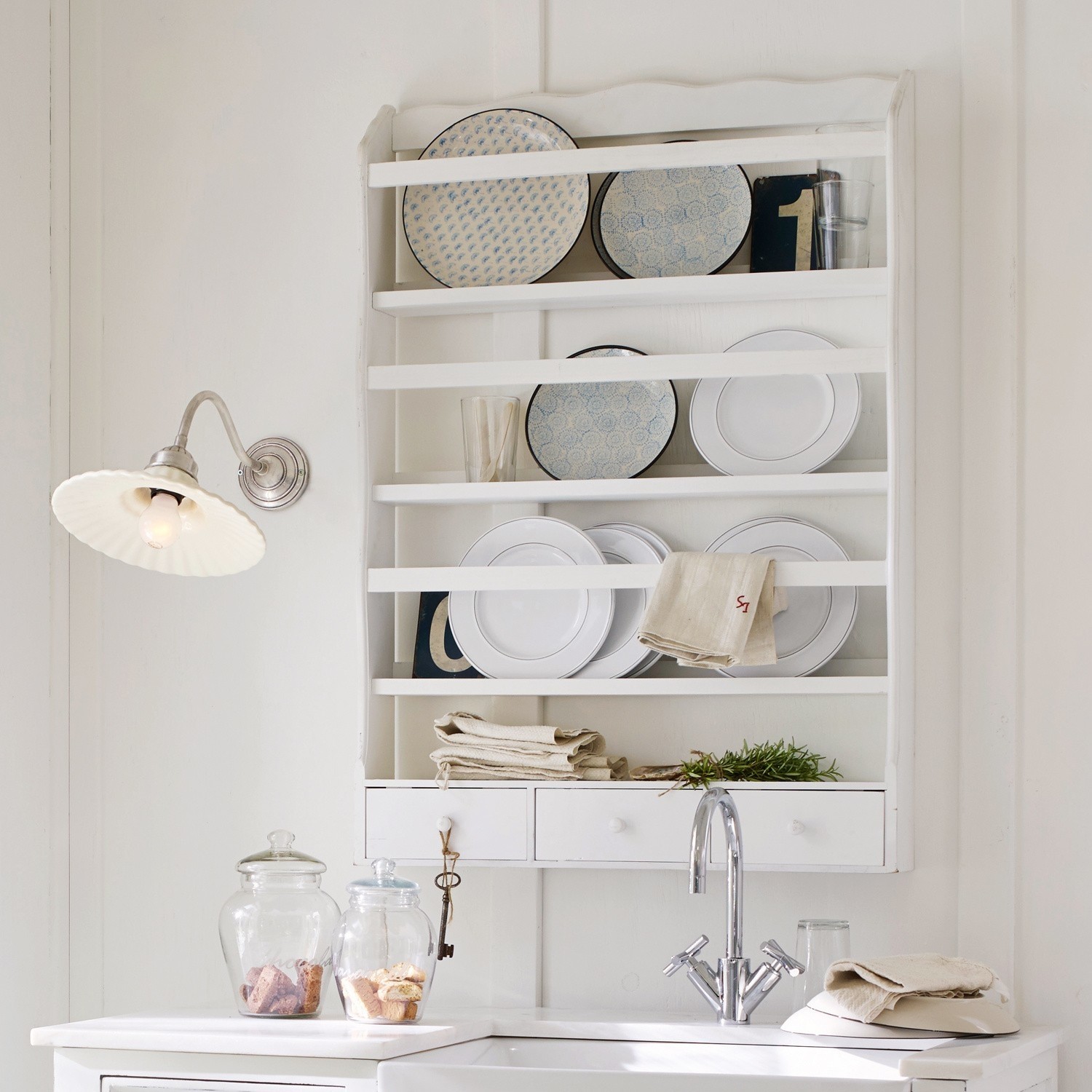 Witte houten keukenplank met borden en glazen, rustieke stijl, keukenwanddecoratie met lades