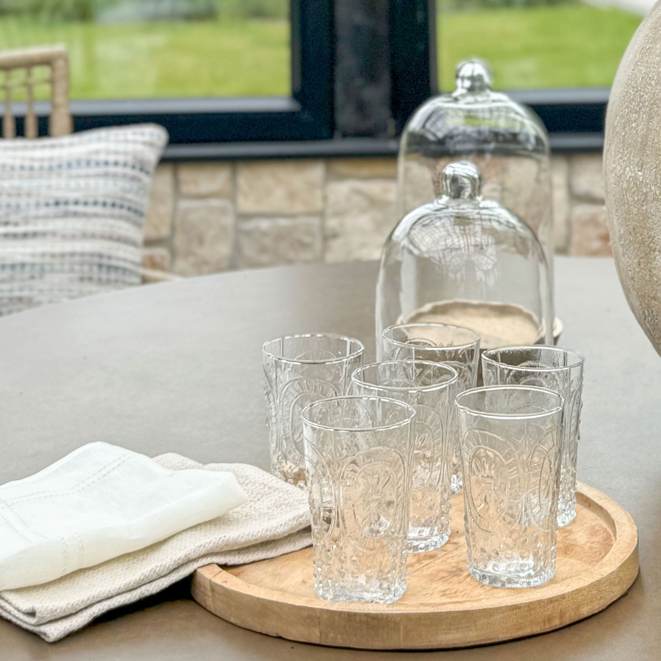 Set van zes transparante glazen met decoratief patroon op een houten dienblad voor het serveren van dranken