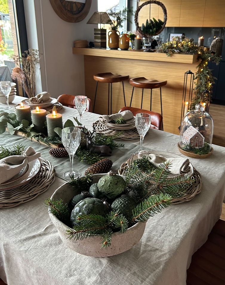 Feestelijk gedekte tafel met natuurlijke groene takken en kaarsen in een gezellige ruimte