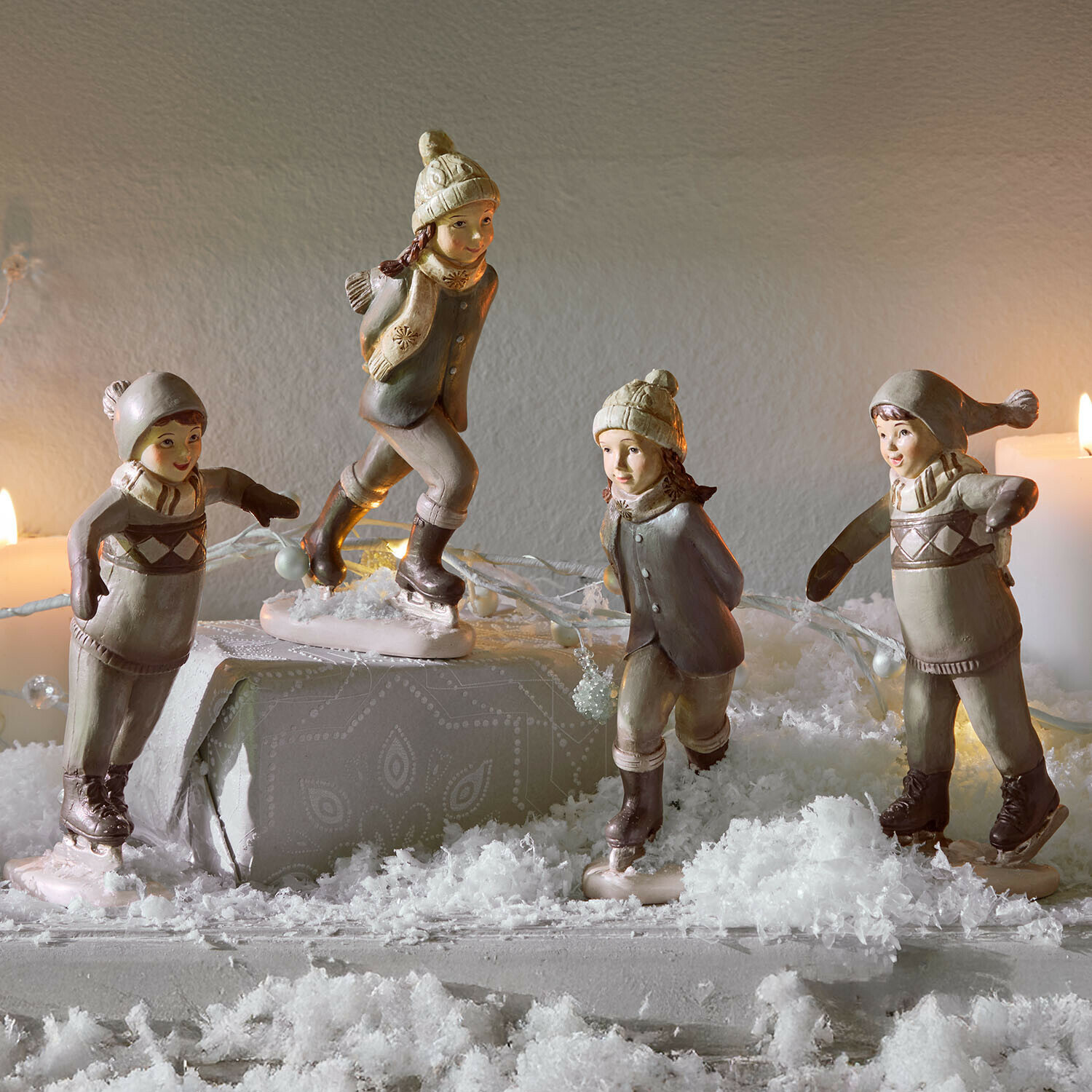 Figuurtje set van 4 Mériot Keramische figuren van kinderen op schaatsen in beige en grijs op een feestelijk gedekte tafel met nepsneeuw