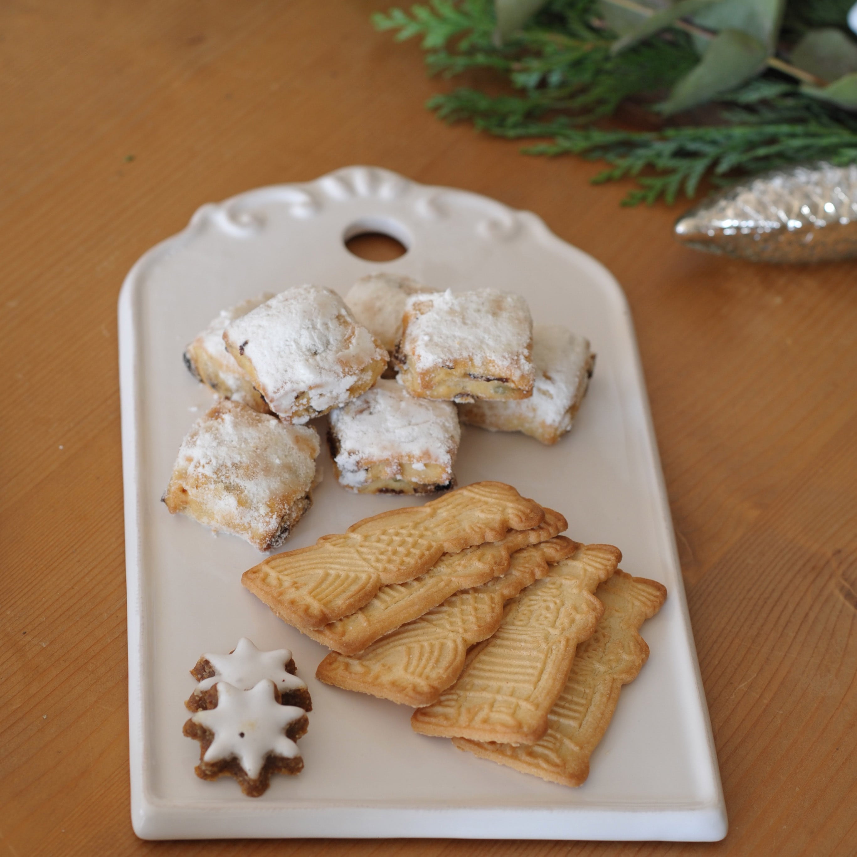 Witte keramische schaal met traditionele kerstkoekjes op houten tafel