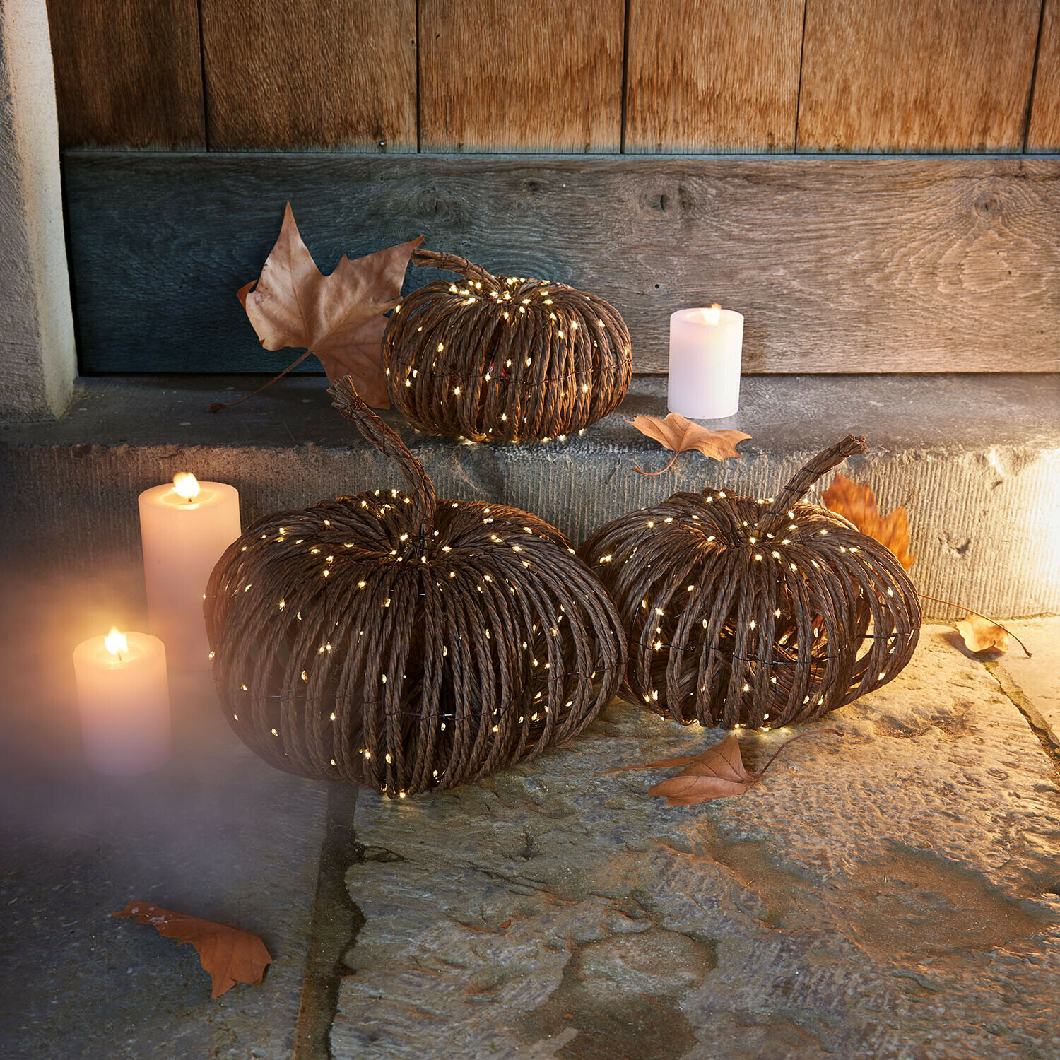 Ledpompoen set van 3 Ysolann Decoratieve pompoenen van donker touw met zachte LED-verlichting en kaarsen op stenen vloer